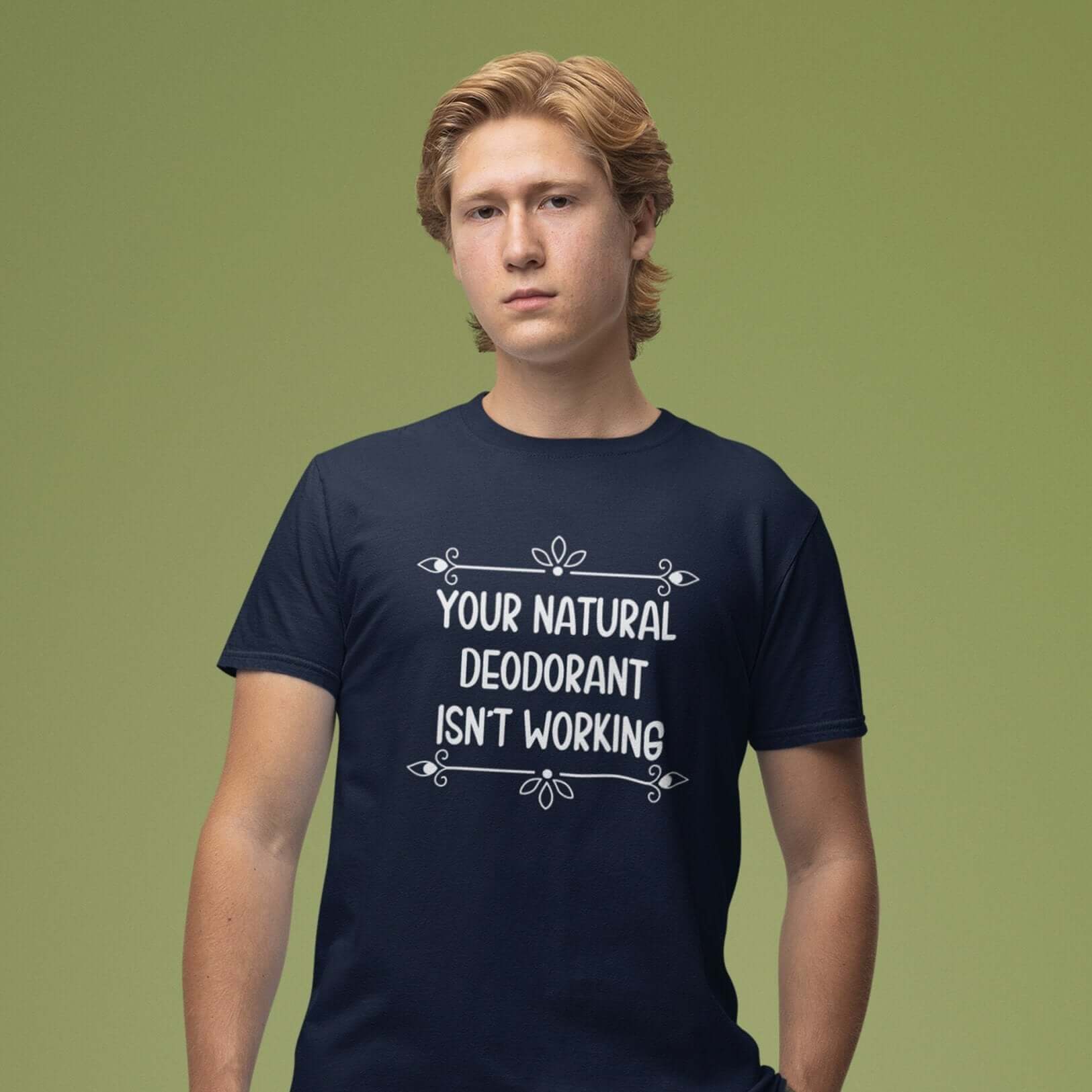 Man wearing a navy blue t-shirt with the funny phrase Your natural deodorant isnt working printed on the front.