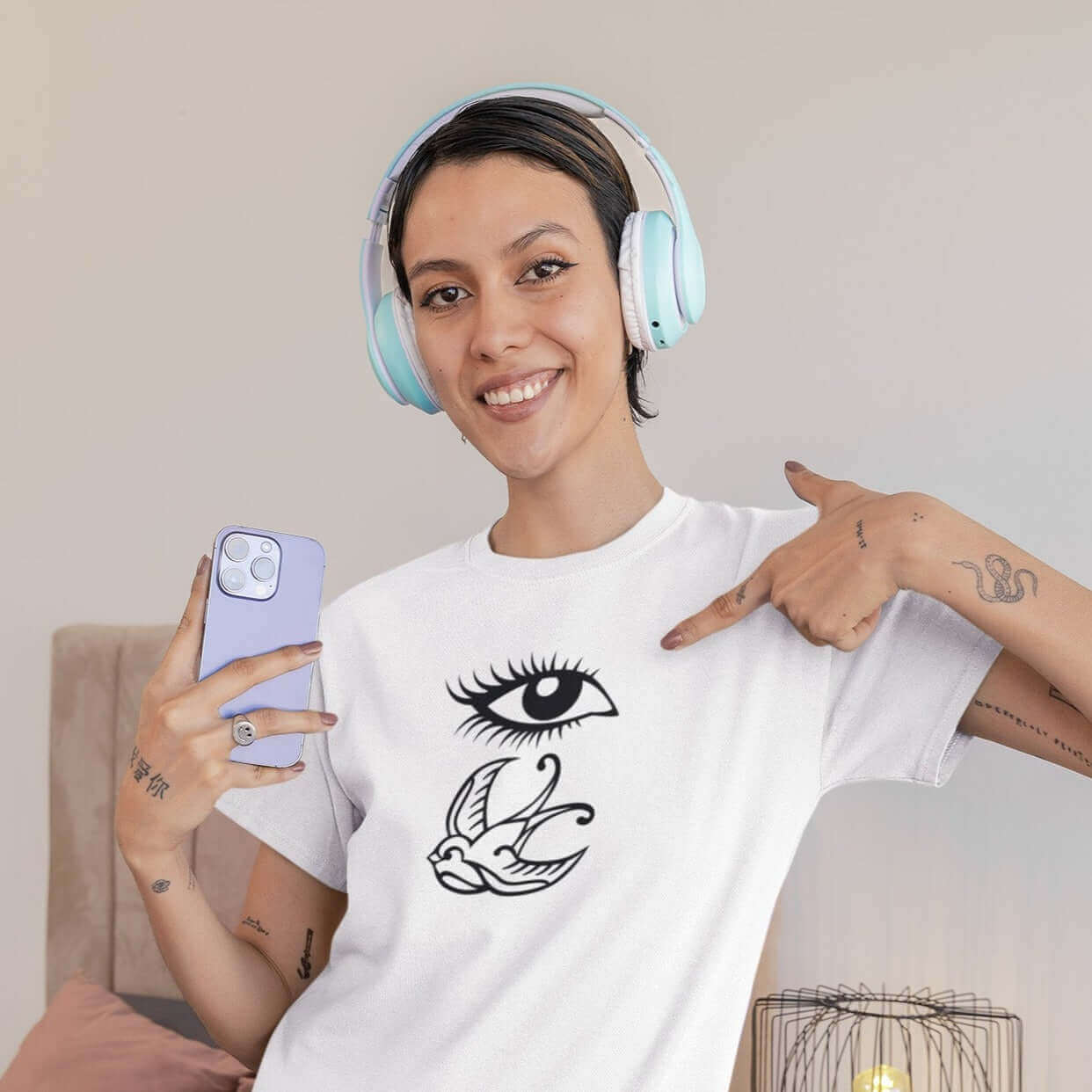 Woman wearing white t-shirt with outline drawing of an eye and a swallow bird printed on the front.