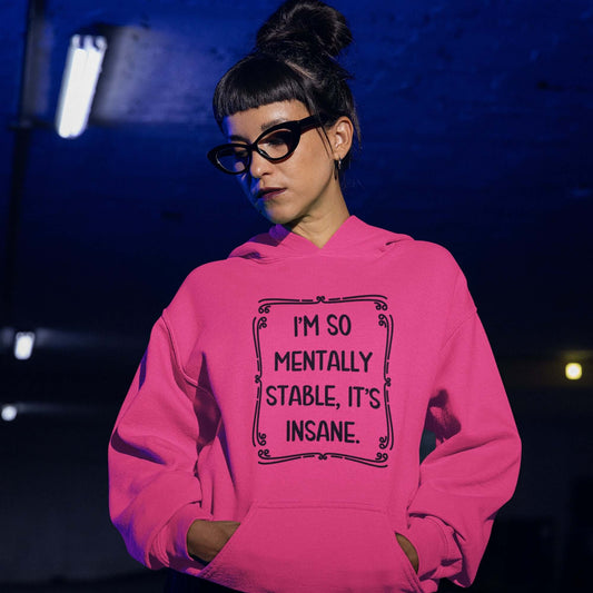 Woman wearing a heliconia pink hoodie sweatshirt with the phrase I'm so mentally stable, it's insane printed on the front.