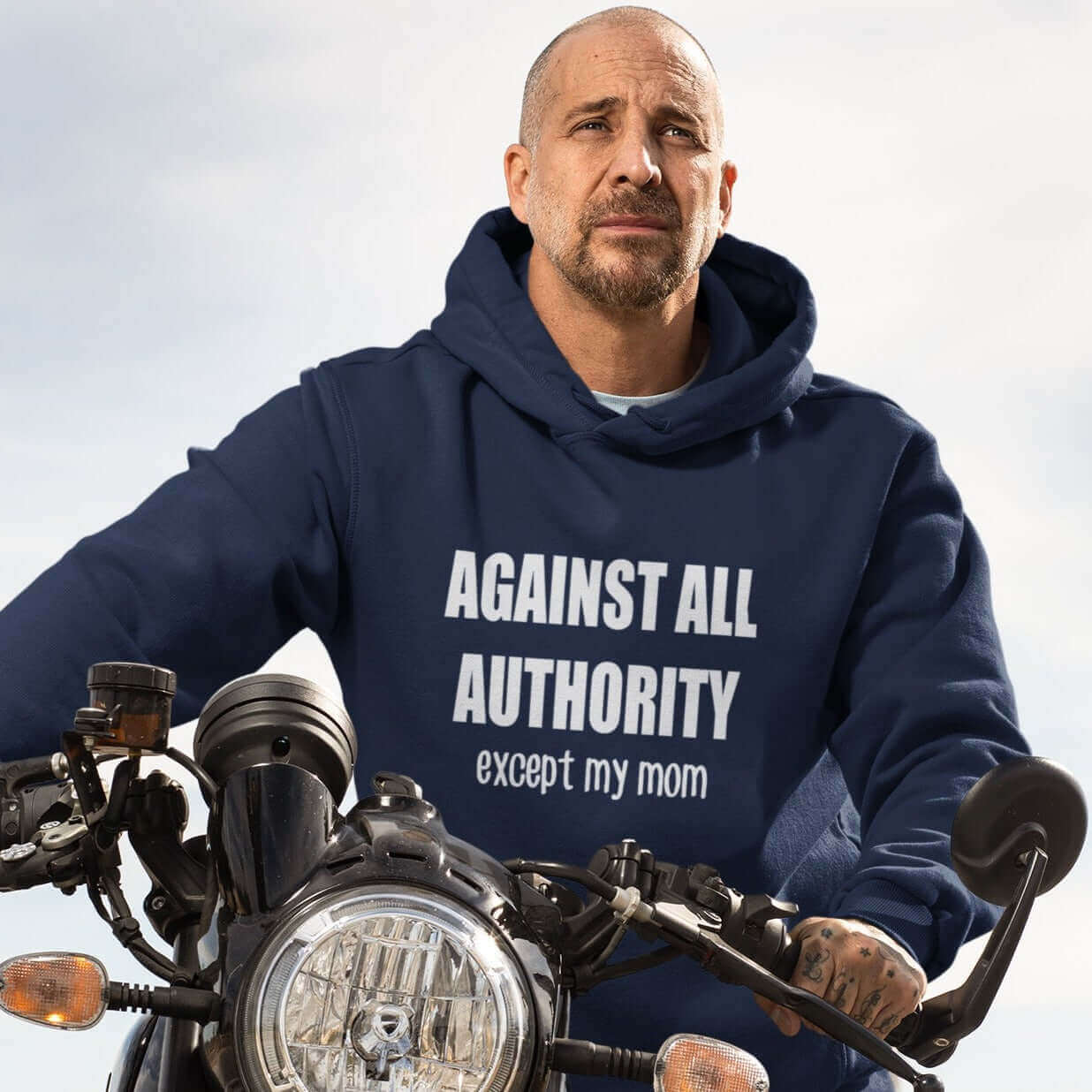 Biker man wearing navy blue hoodie sweatshirt that has Against all authority except my mom printed on the front.