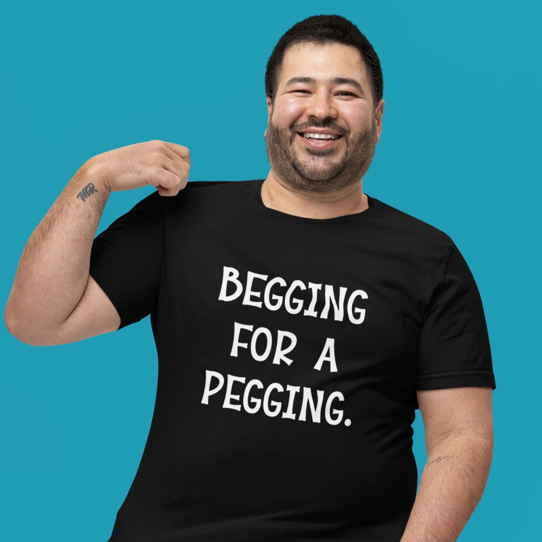 Man wearing black t-shirt with the words Begging for a pegging printed on the front.