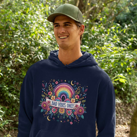 Man wearing a navy blue hoodie sweatshirt with a colorful boho rainbow floral design and the phrase Bad Vibes Only printed on the front.