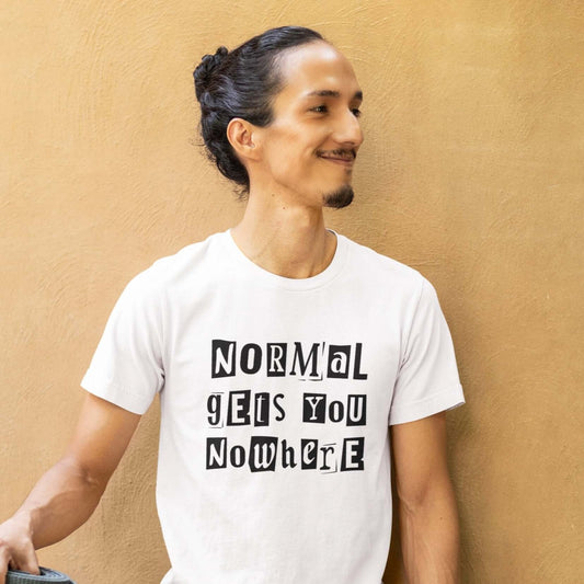 Smiling man wearing a white t-shirt with the phrase Normal gets you nowhere printed on the front.