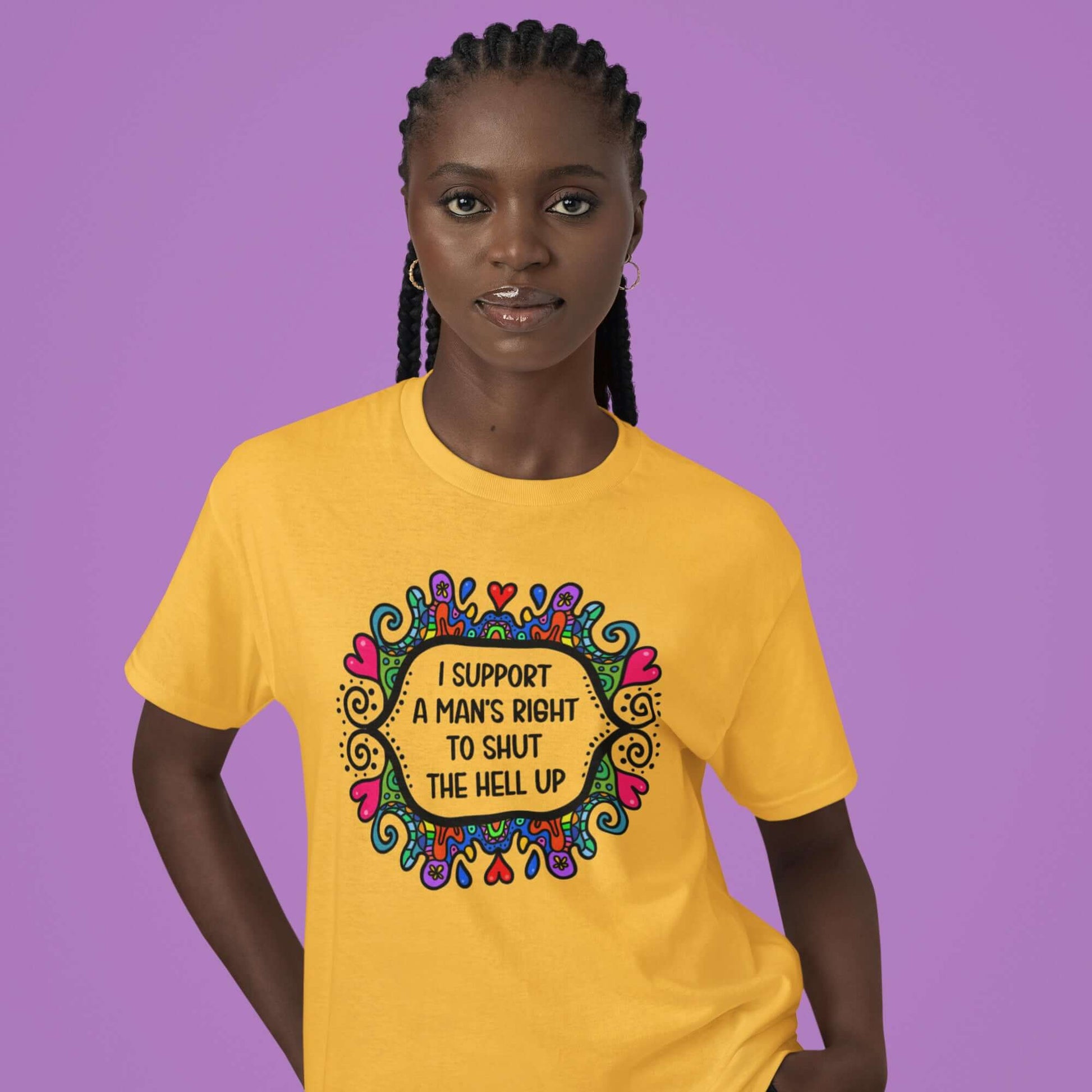 Woman wearing a daisy yellow t-shirt with a colorful doodle graphic and the words I support a man's right to shut the hell up printed on the front.