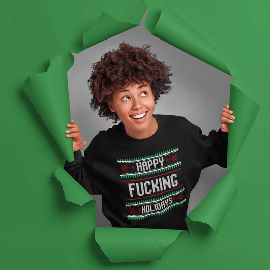 Woman wearing a black crewneck sweatshirt with the phrase Happy fucking holidays printed on the front. The graphics are printed like a knitted Christmas sweater.