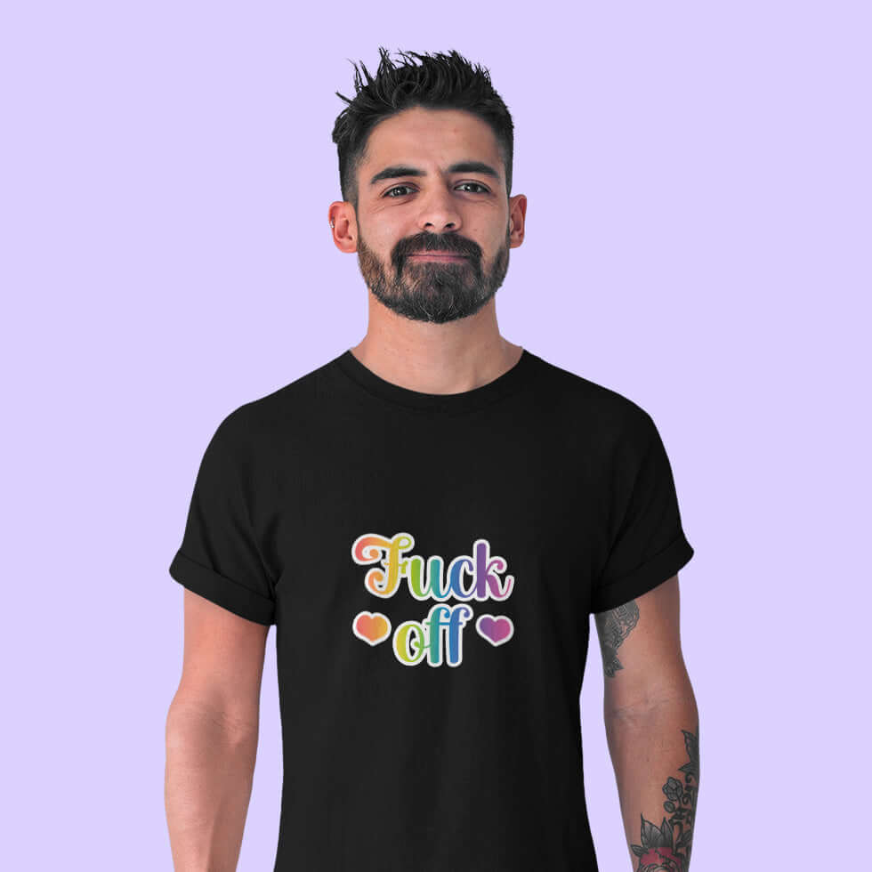 Man wearing a black t-shirt with the words Fuck off printed in 80's style rainbow font. The graphics are printed on the front of the shirt.