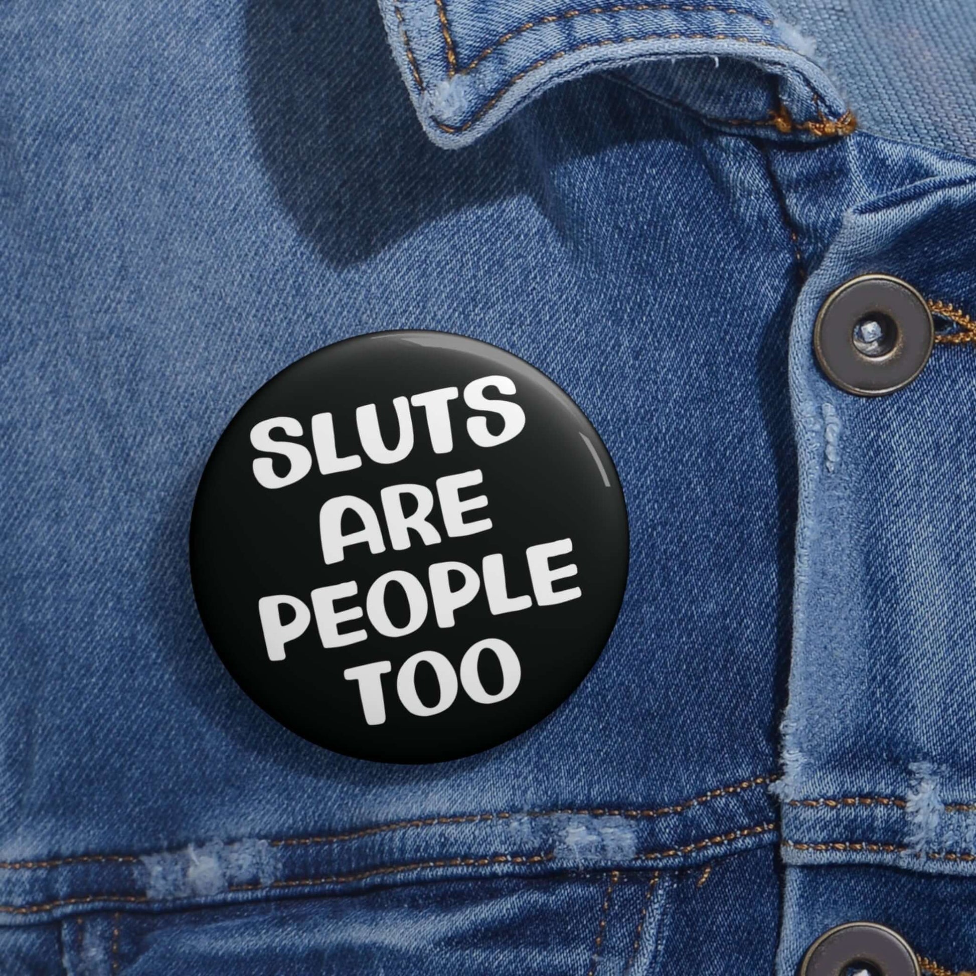 Black pinback button that says Sluts are people too.