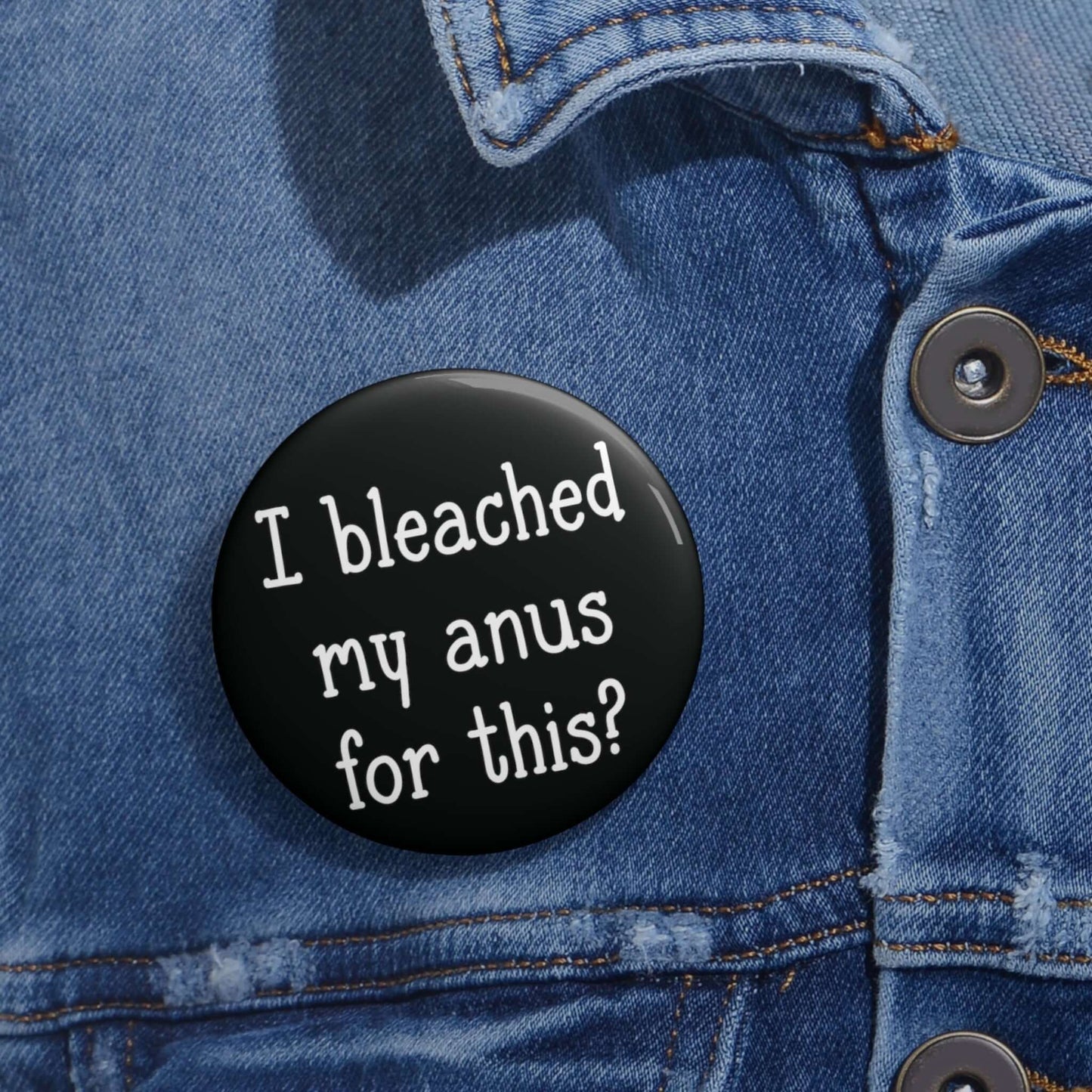 black pinback button with the words "I bleached my anus for this" printed on