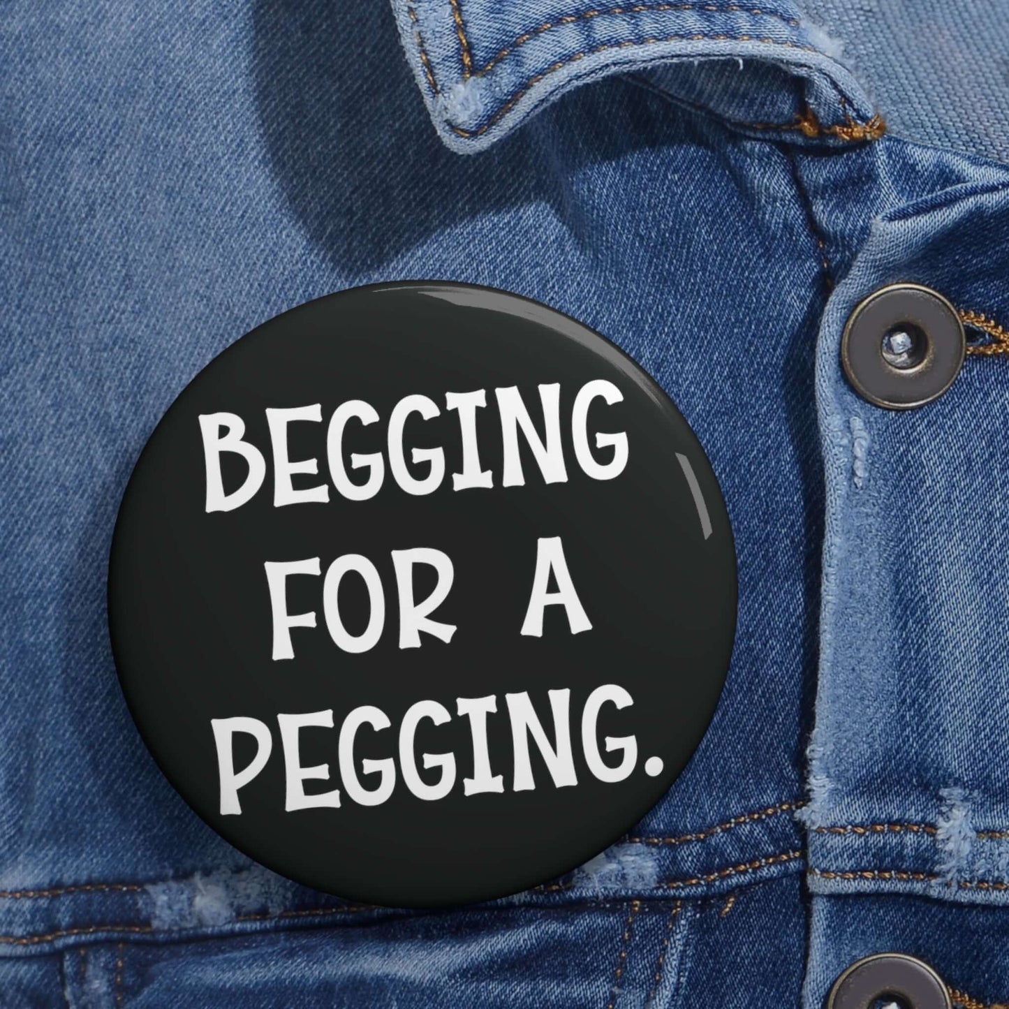 Black pin-back button that says begging for a pegging.