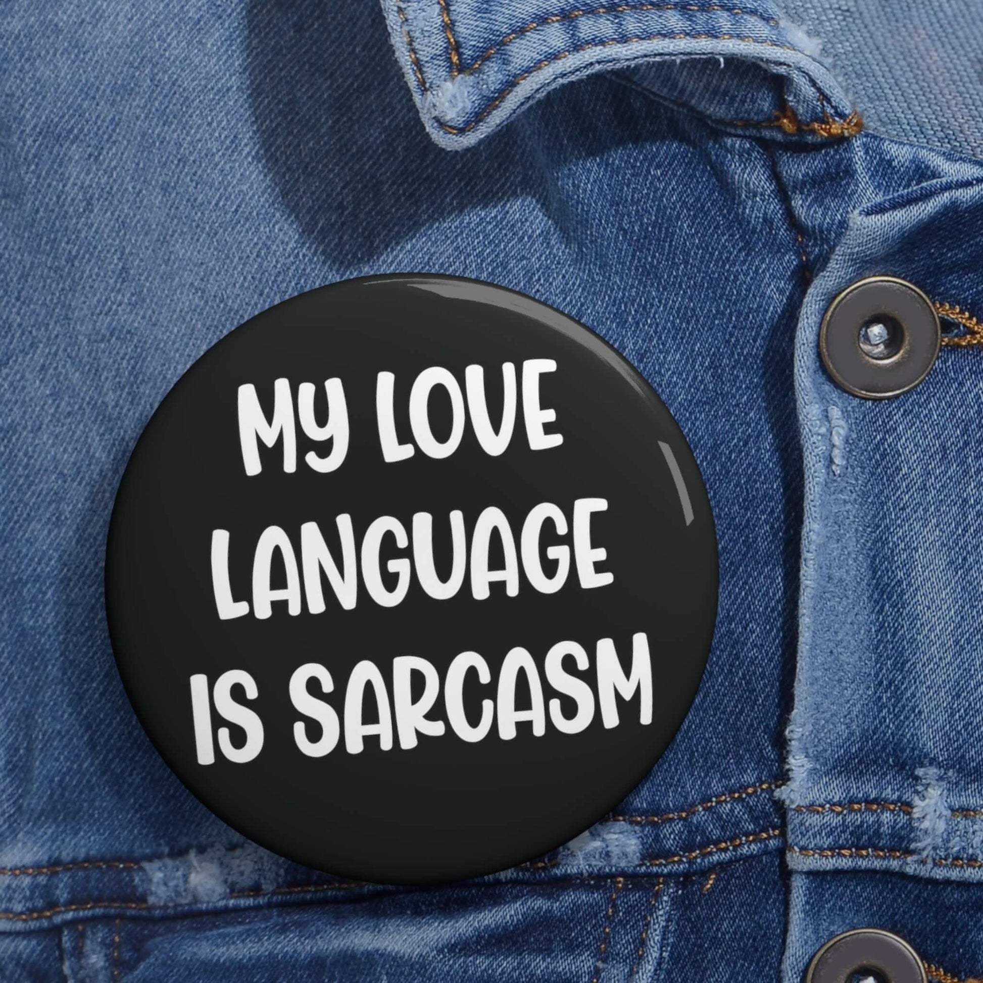 Black pin-back button with the phrase My love language is sarcasm printed in white.