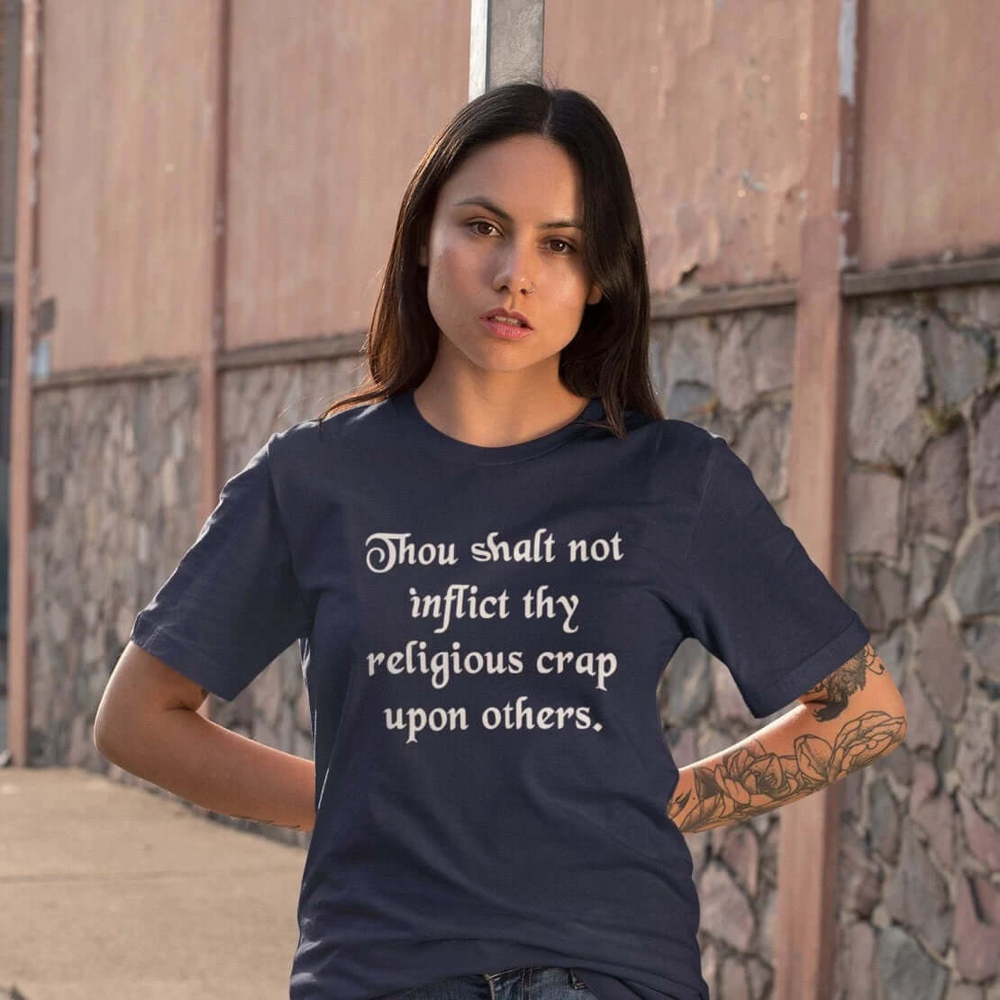 Woman wearing navy blue t-shirt with the phrase Thou shalt not inflict thy religious crap upon others printed on the front.