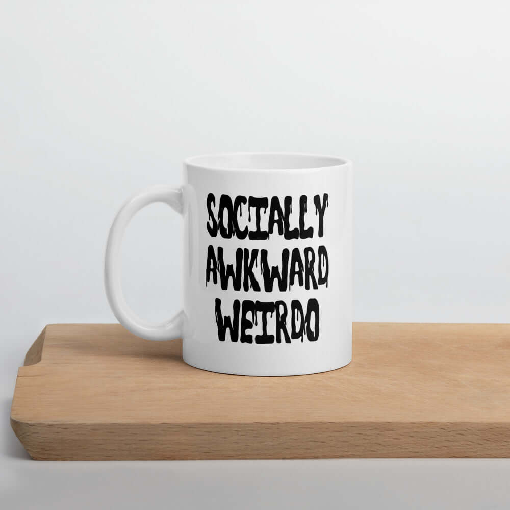 White ceramic coffee mug with the words socially awkward weirdo printed on both sides.