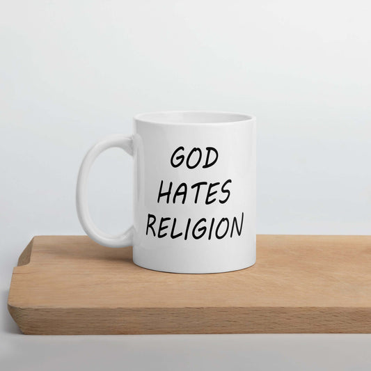 White ceramic mug with with the words God hates religion printed on both sides of the mug.