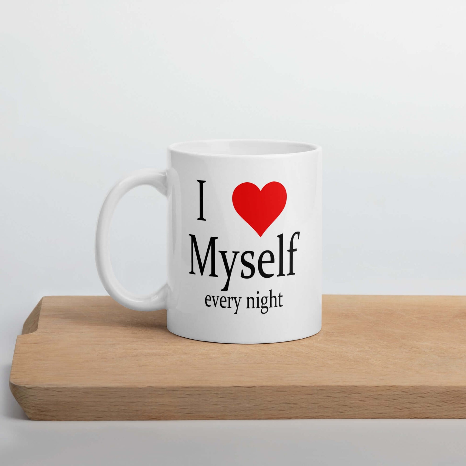 White ceramic coffee mug with the phrase I heart myself every night printed on both sides.