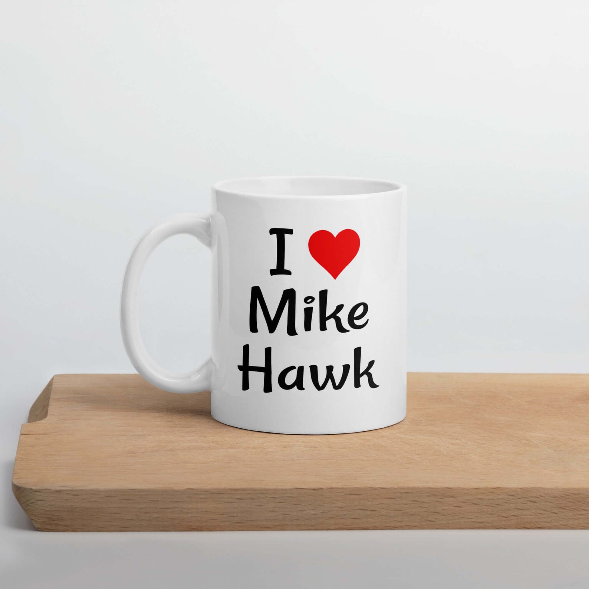 White ceramic coffee mug with the pun I heart Mike Hawk printed on both sides of the mug.