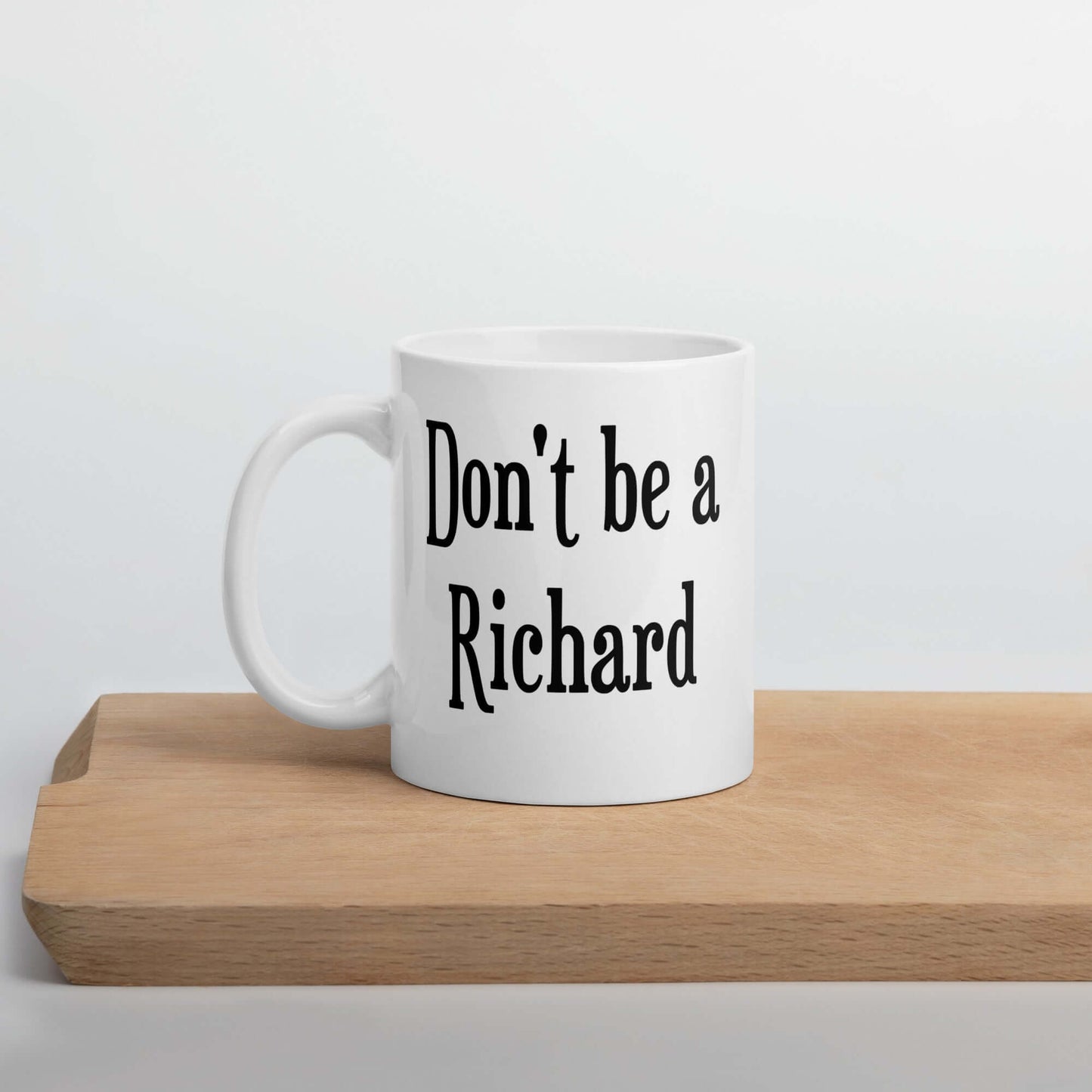 White ceramic mug with the phrase Don't be a Richard printed on both sides of the mug.