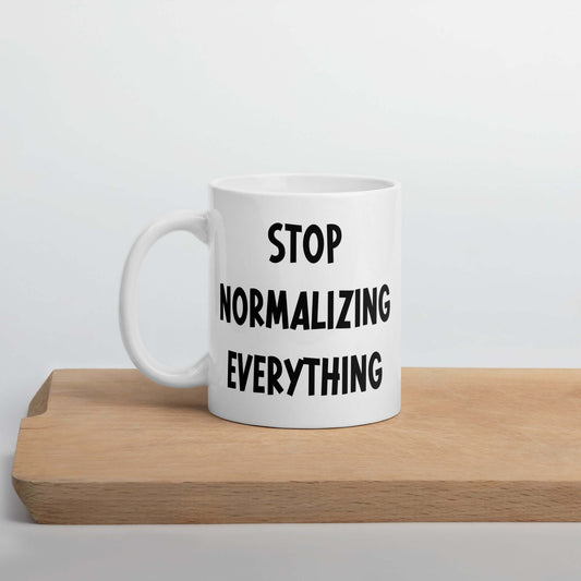 White ceramic coffee mug with stop normalizing everything printed on both sides.