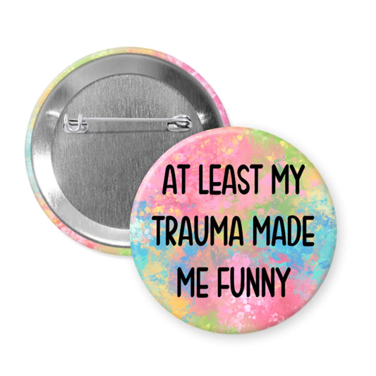 Button badge with 'At least my trauma made me funny' text on a colorful background