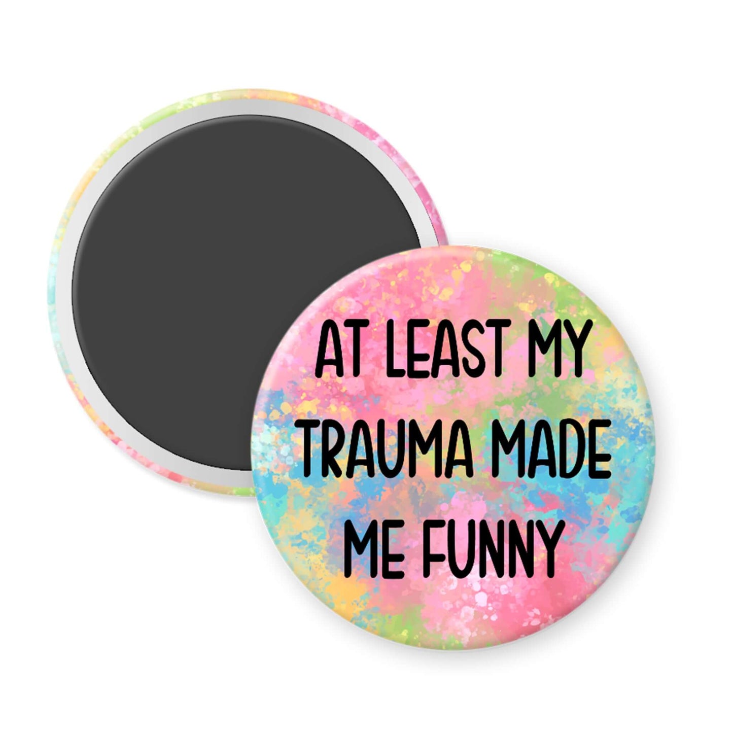Round magnet with colorful splatter design and text 'AT LEAST MY TRAUMA MADE ME FUNNY' on a white background