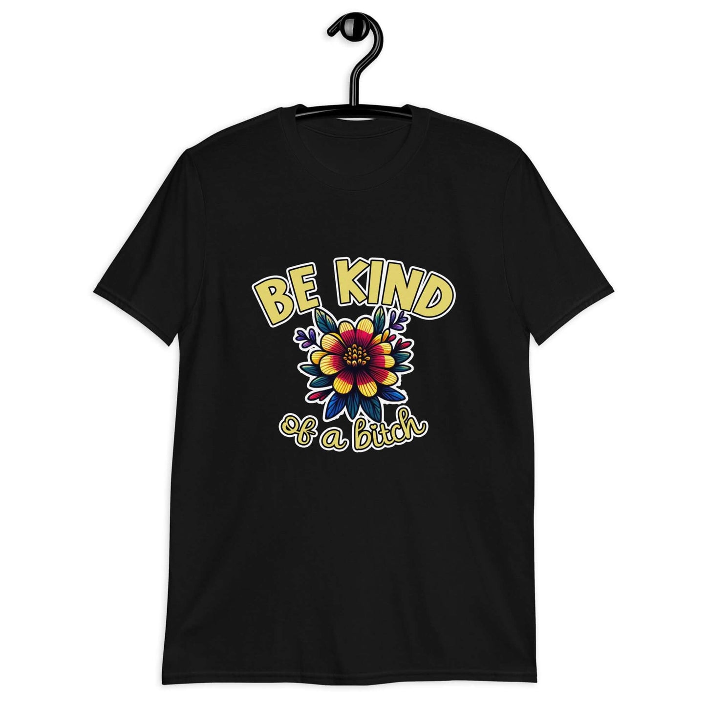 Black t-shirt with an image of a flower and the words Be kind above the flower in yellow bold block font. The words Of a bitch are smaller in script font under the flower. The design is printed on the front of the shirt.