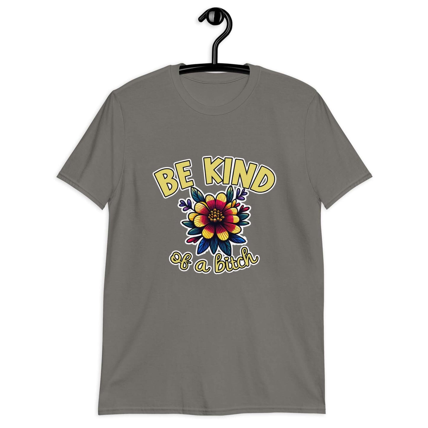 Charcoal grey t-shirt with an image of a flower and the words Be kind above the flower in yellow bold block font. The words Of a bitch are smaller in script font under the flower. The design is printed on the front of the shirt.