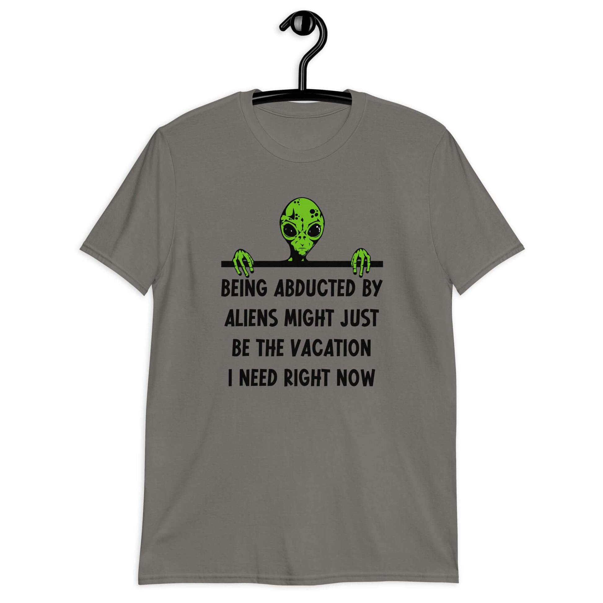 Charcoal grey t-shirt with an image of a green alien and the phrase Being abducted by aliens might just be the vacation I need right now printed on the front of the shirt.