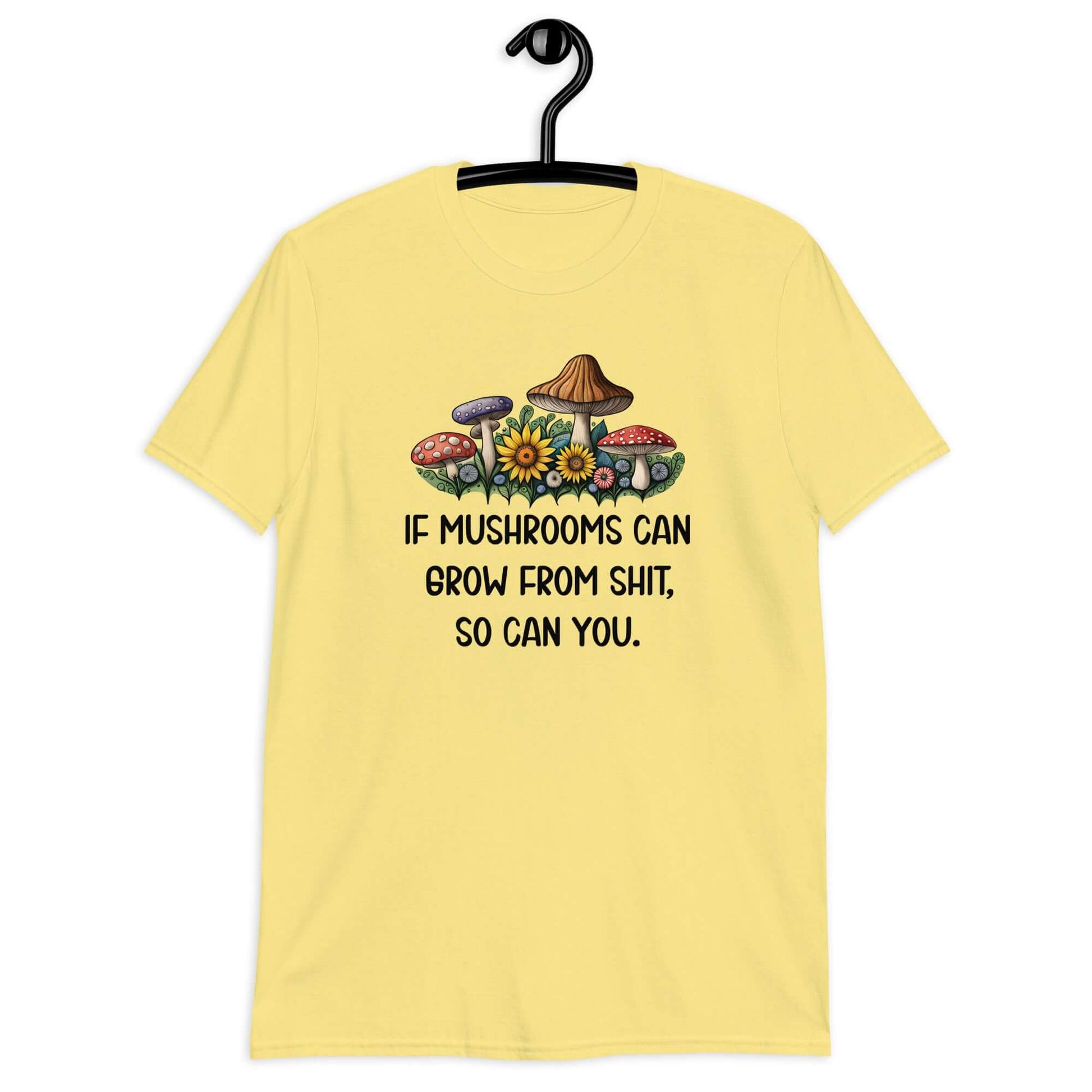 Cornsilk yellow t-shirt with images of mushrooms and the phrase If mushrooms can grow from shit so can you printed on the front.