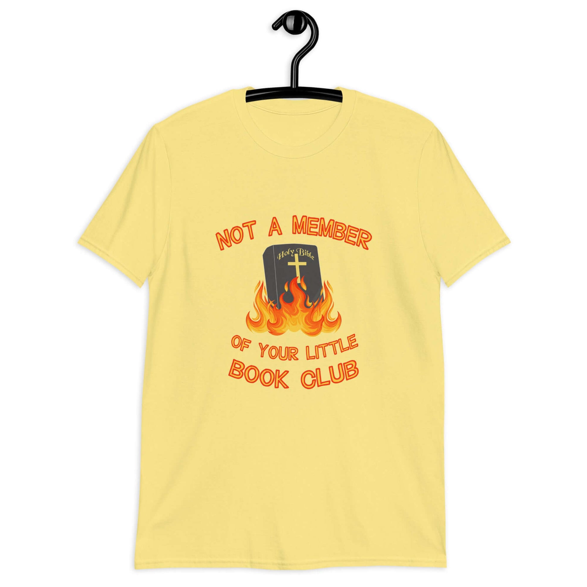 Cornsilk yellow t-shirt with image of a burning bible and the words Not a member of your little book club printed on the front.