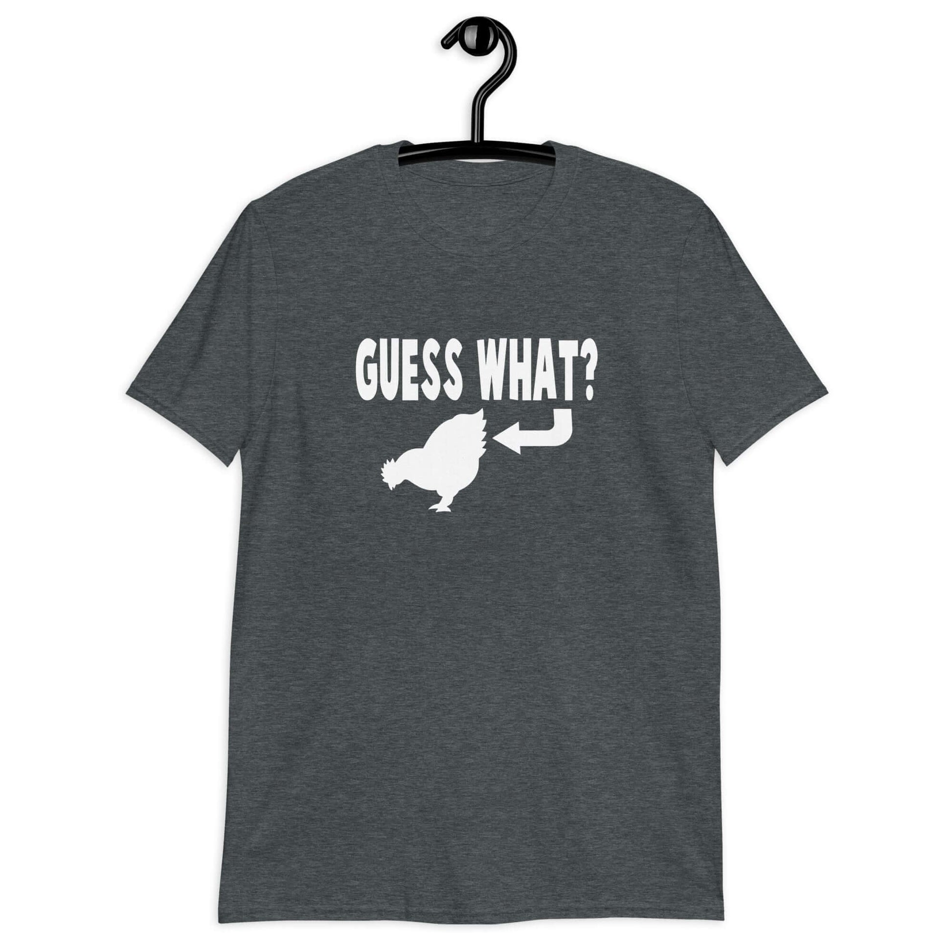 Dark heather t-shirt with an image of a chicken and the words Guess what question mark. There is an arrow pointing to the chickens butt. The graphics are printed on the front of the shirt.