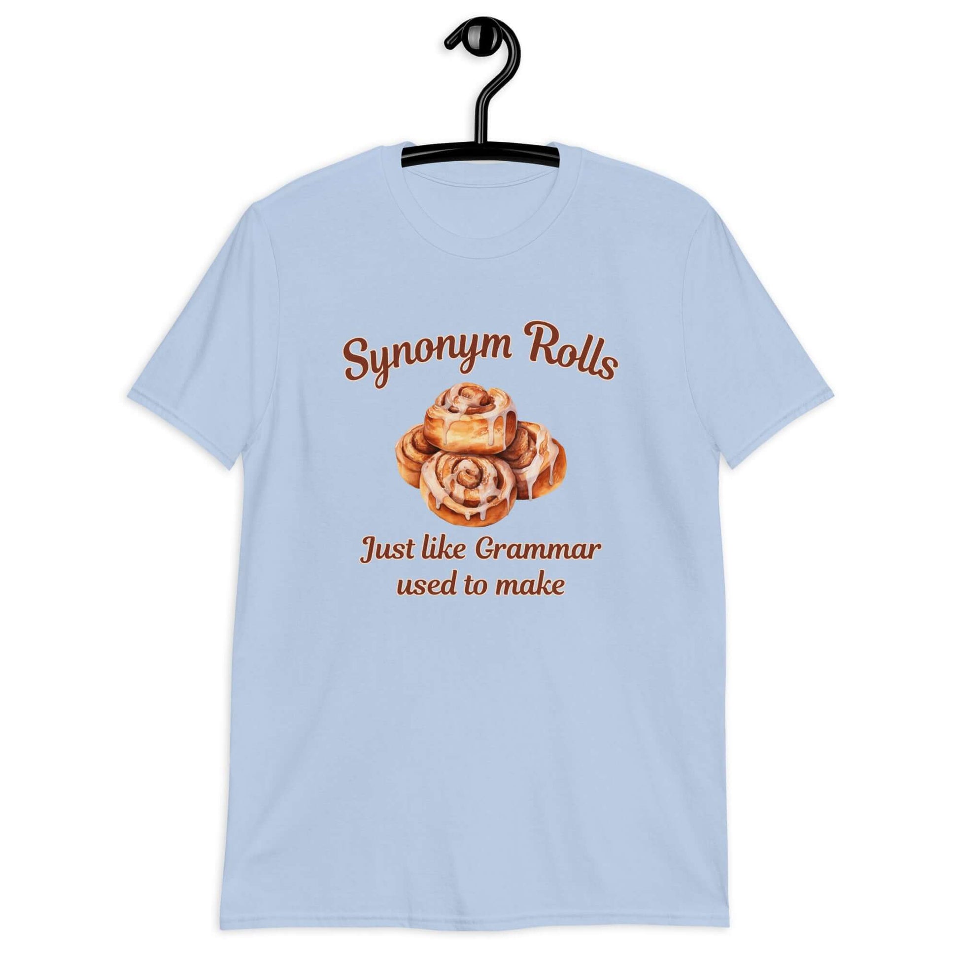 Light blue t-shirt with an image of cinnamon rolls and the pun phrase Synonym rolls Just like Grammar used to make printed on the front.