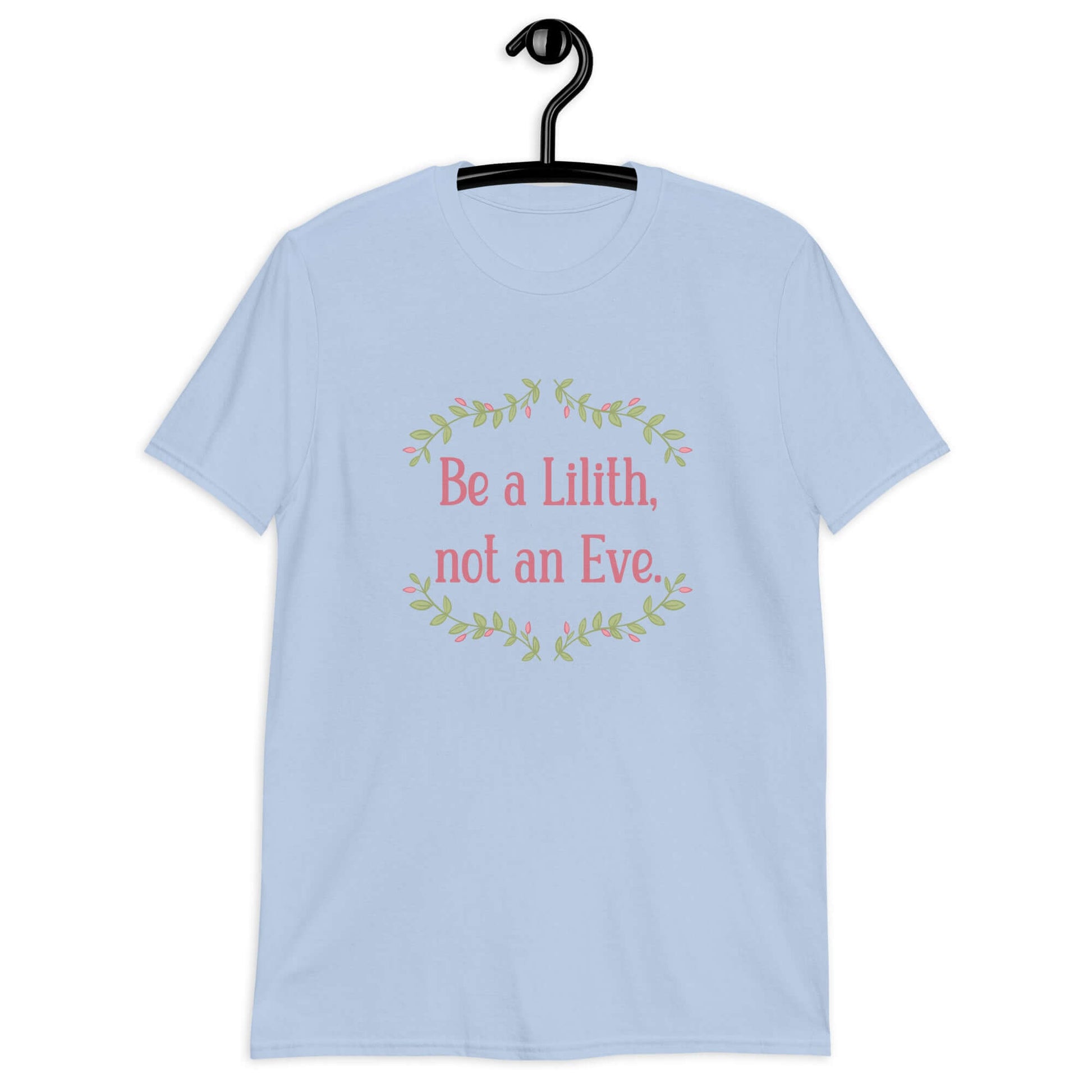 Light blue t-shirt with the phrase Be a Lilith, not an Eve printed on the front. The text is pink and had a green floral vine graphic framing the text. 