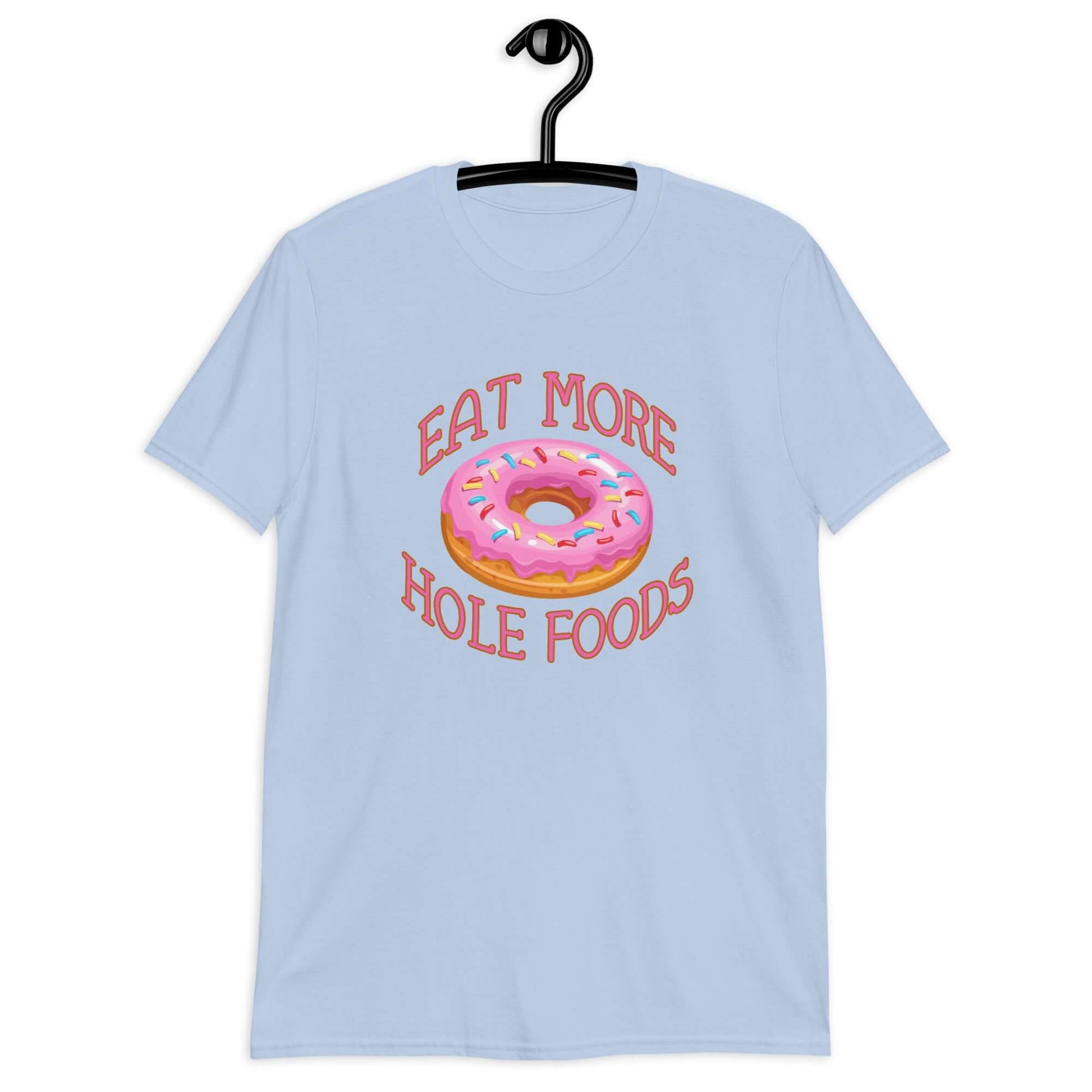 Light blue t-shirt that has an image of a donut with pink icing and sprinkles and Eat more hole foods printed on the front.