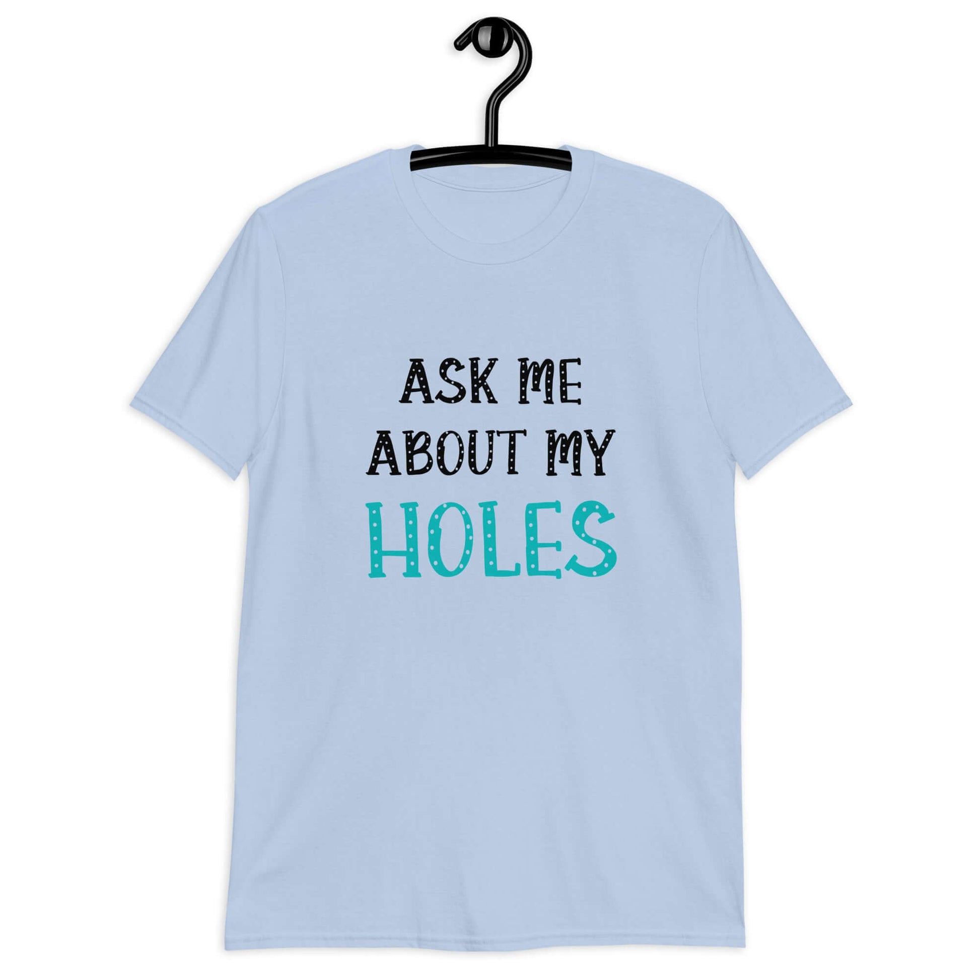 Light blue t-shirt with the words Ask me about my holes printed on the front. The word holes in turquoise color and the rest of the text is black.