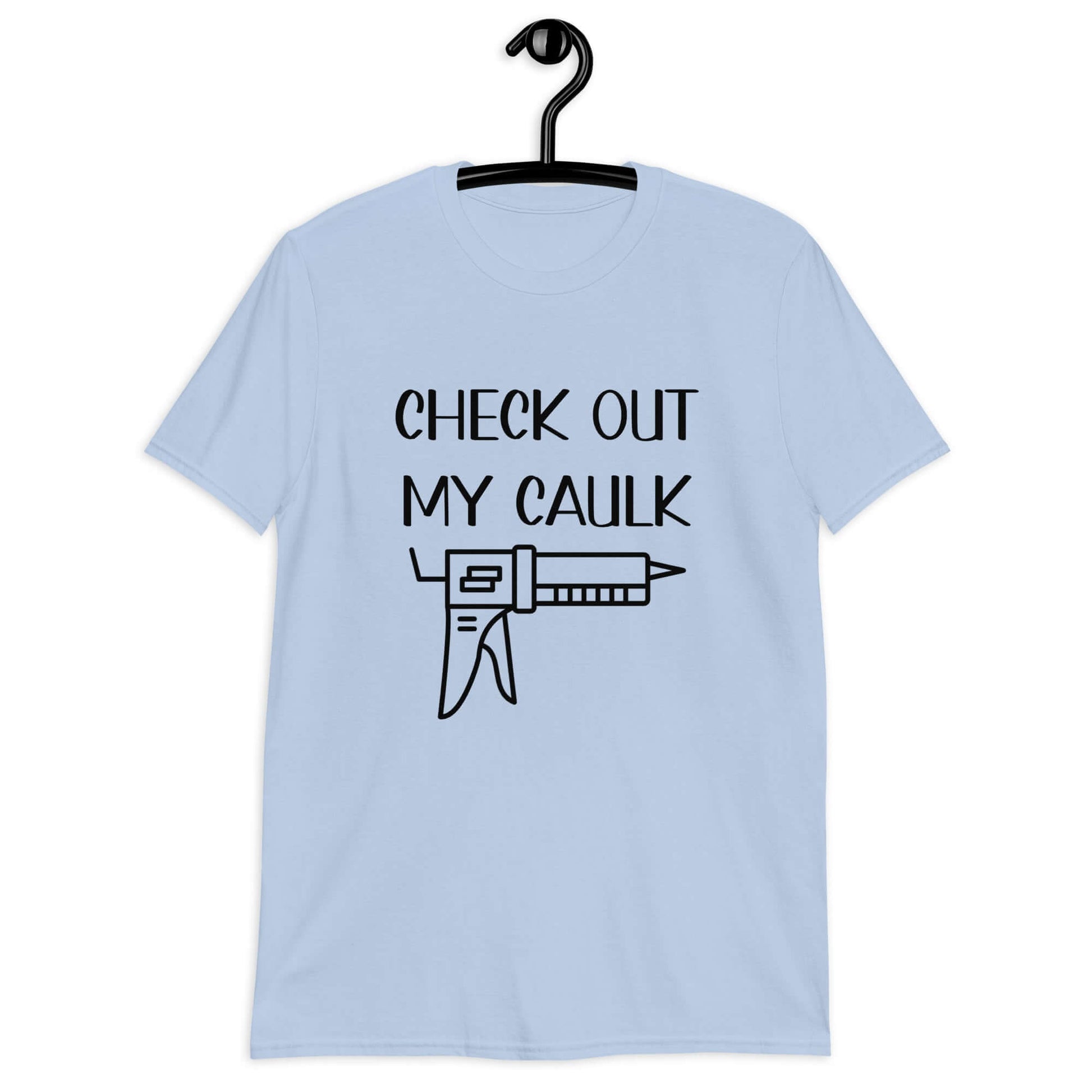 Light blue t-shirt with the pun phrase Check out my caulk with a line drawing image of a caulking gun printed on the front.