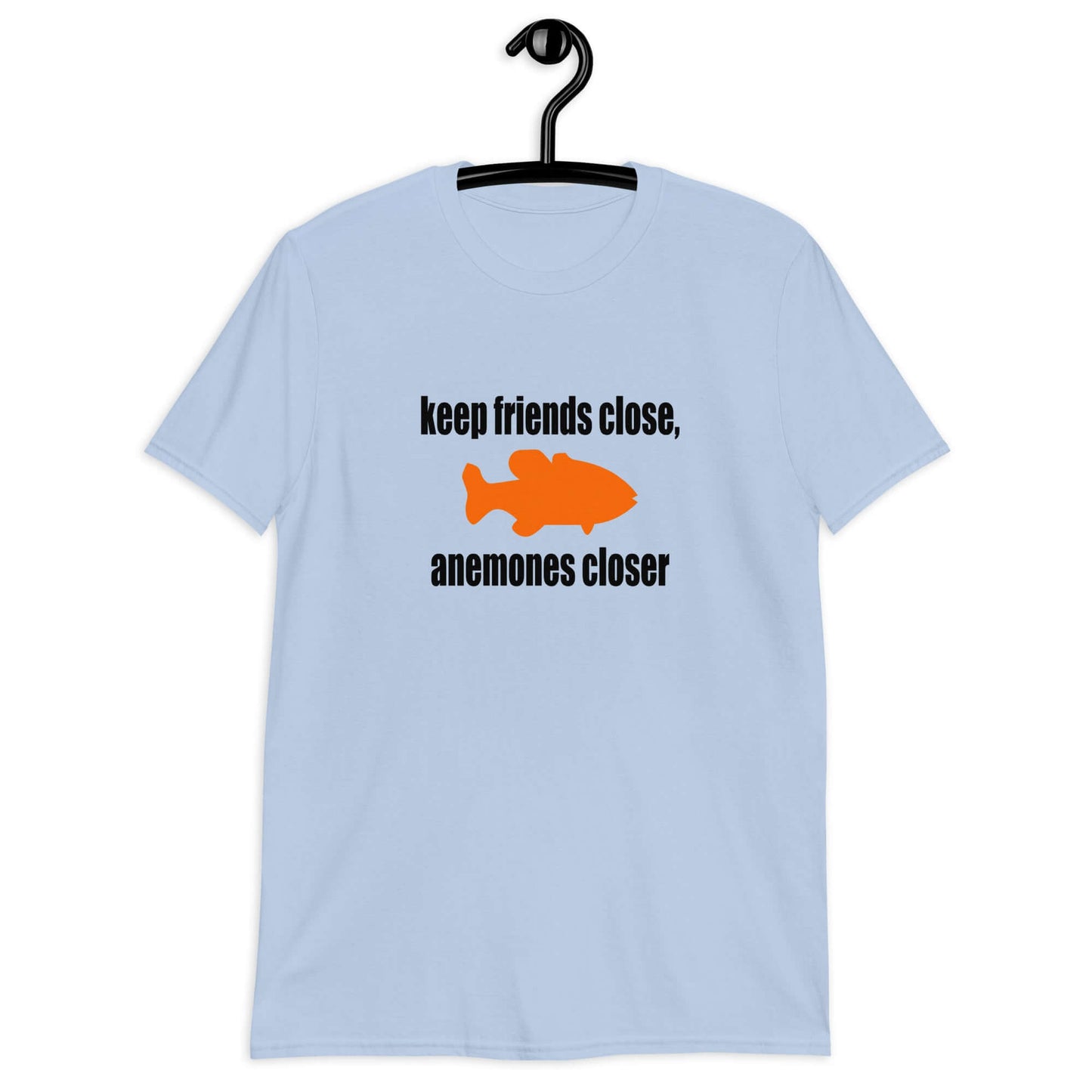 Light blue t-shirt with the pun phrase Keep friends close, anemones closer with an image of an orange fish.