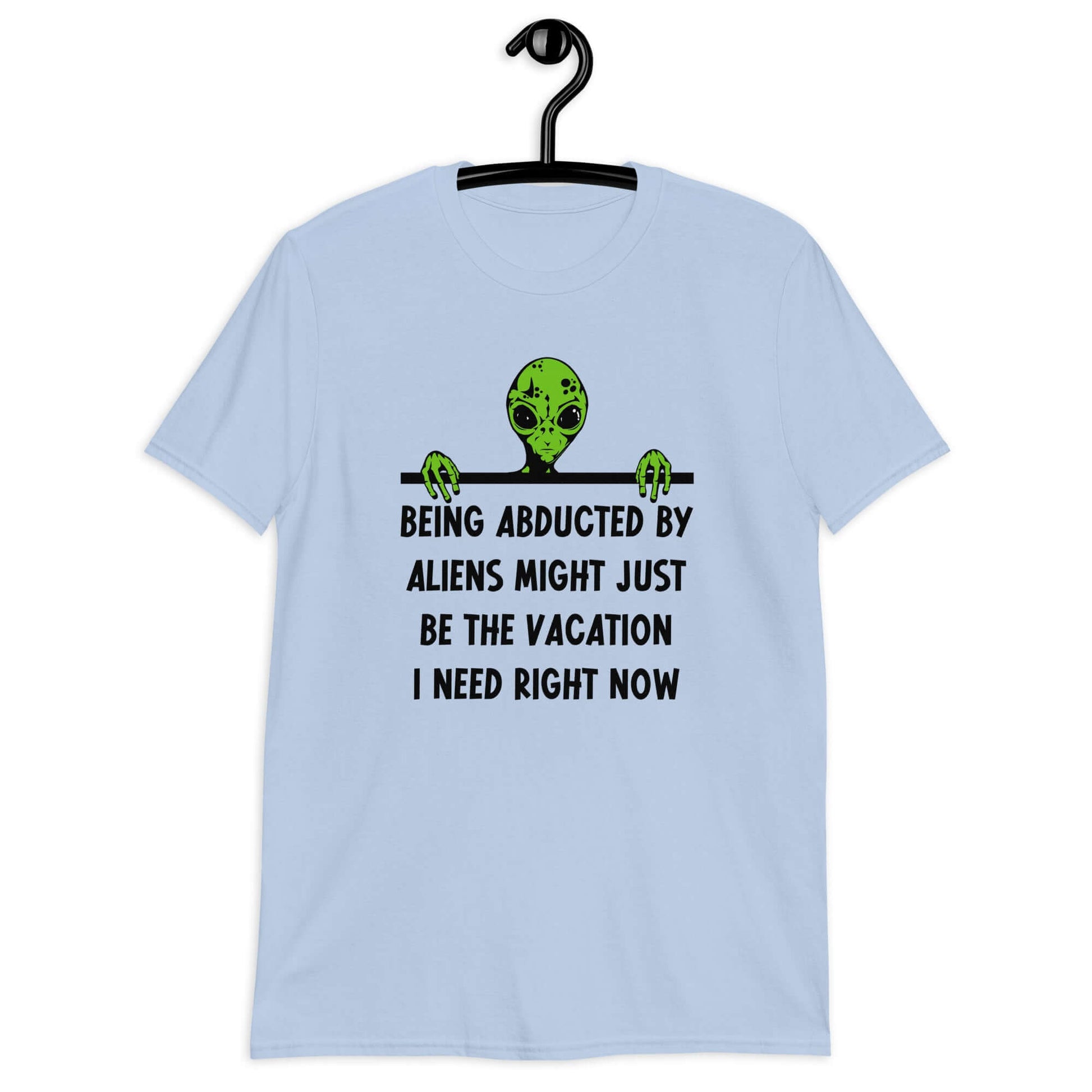 Light blue t-shirt with an image of a green alien and the phrase Being abducted by aliens might just be the vacation I need right now printed on the front of the shirt.