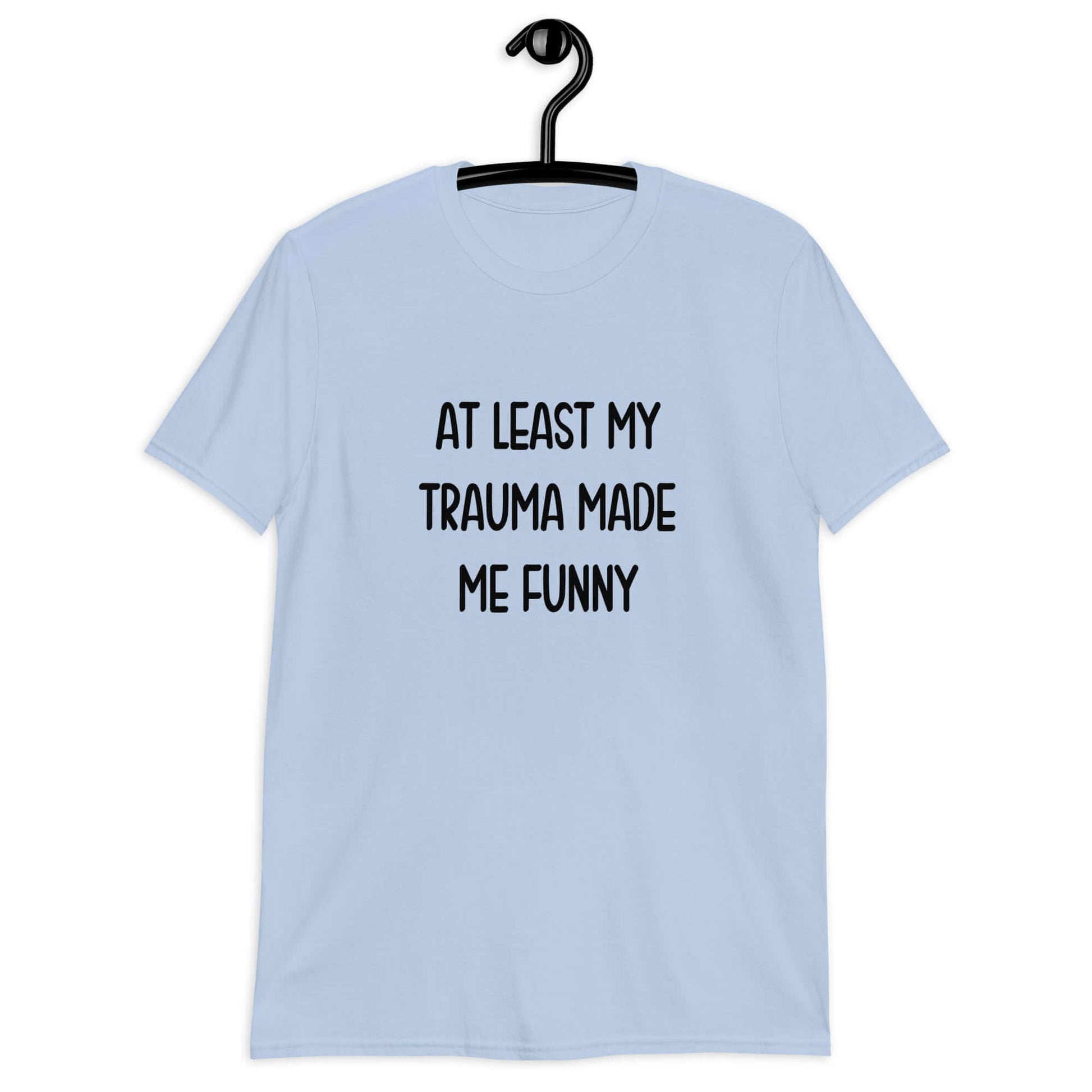 Light blue t-shirt with the words At least my trauma made me funny printed on the front.