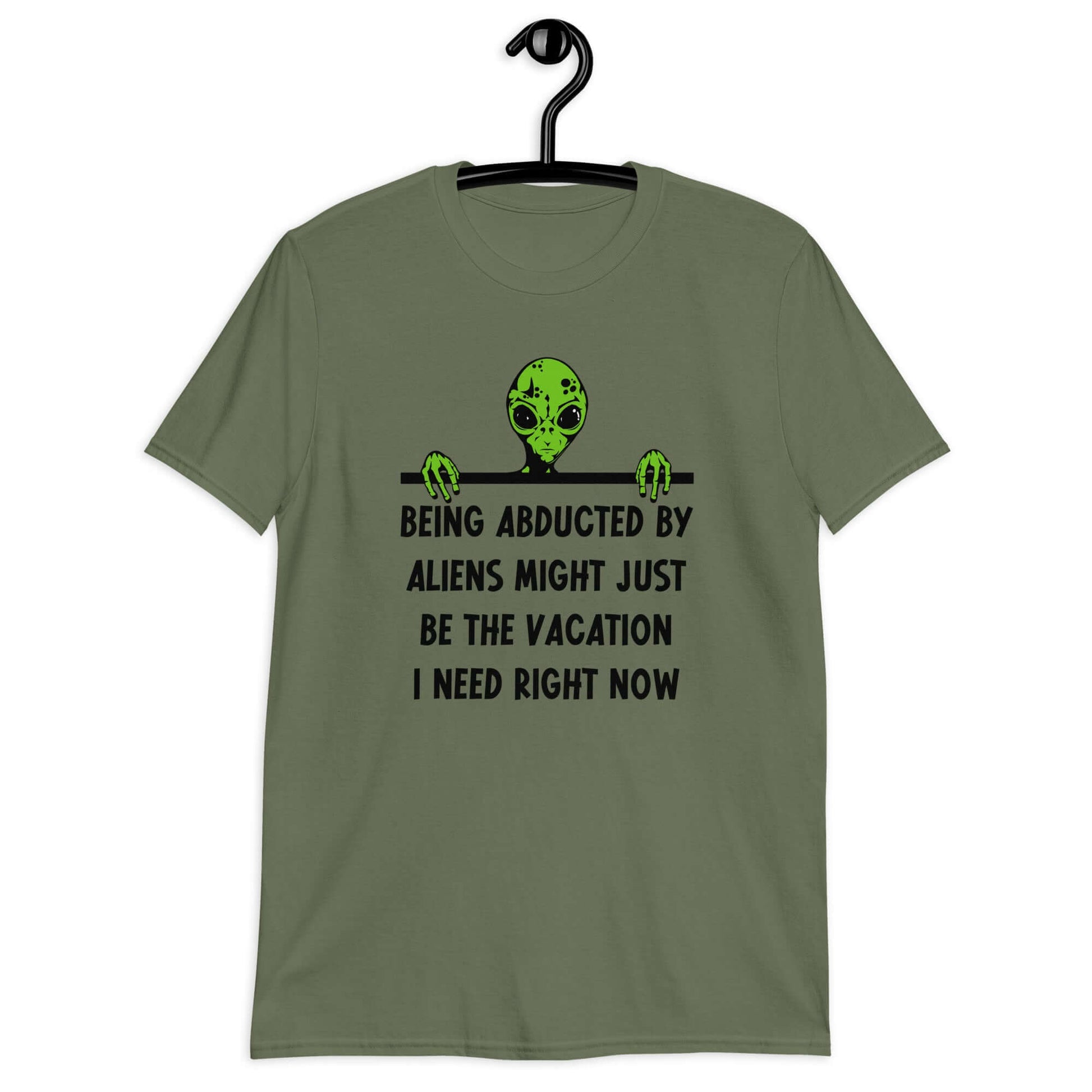 Military green t-shirt with an image of a green alien and the phrase Being abducted by aliens might just be the vacation I need right now printed on the front of the shirt.