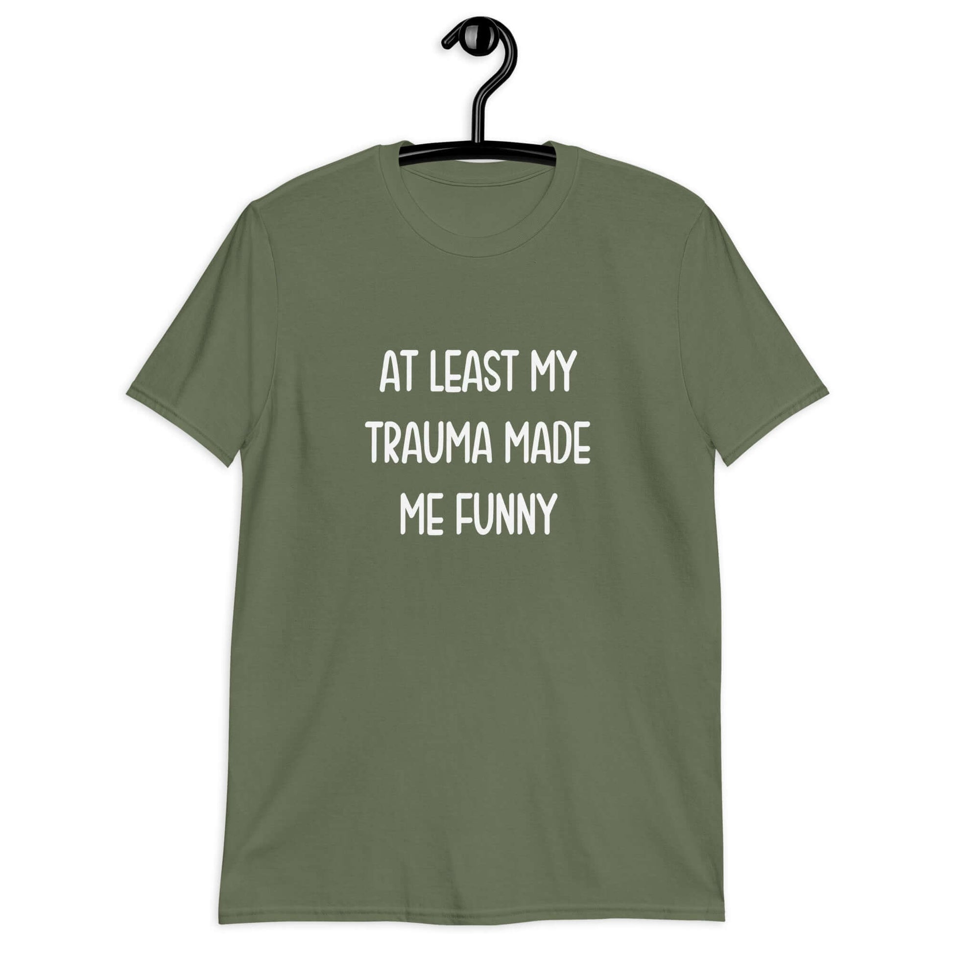 Military green t-shirt with the words At least my trauma made me funny printed on the front.