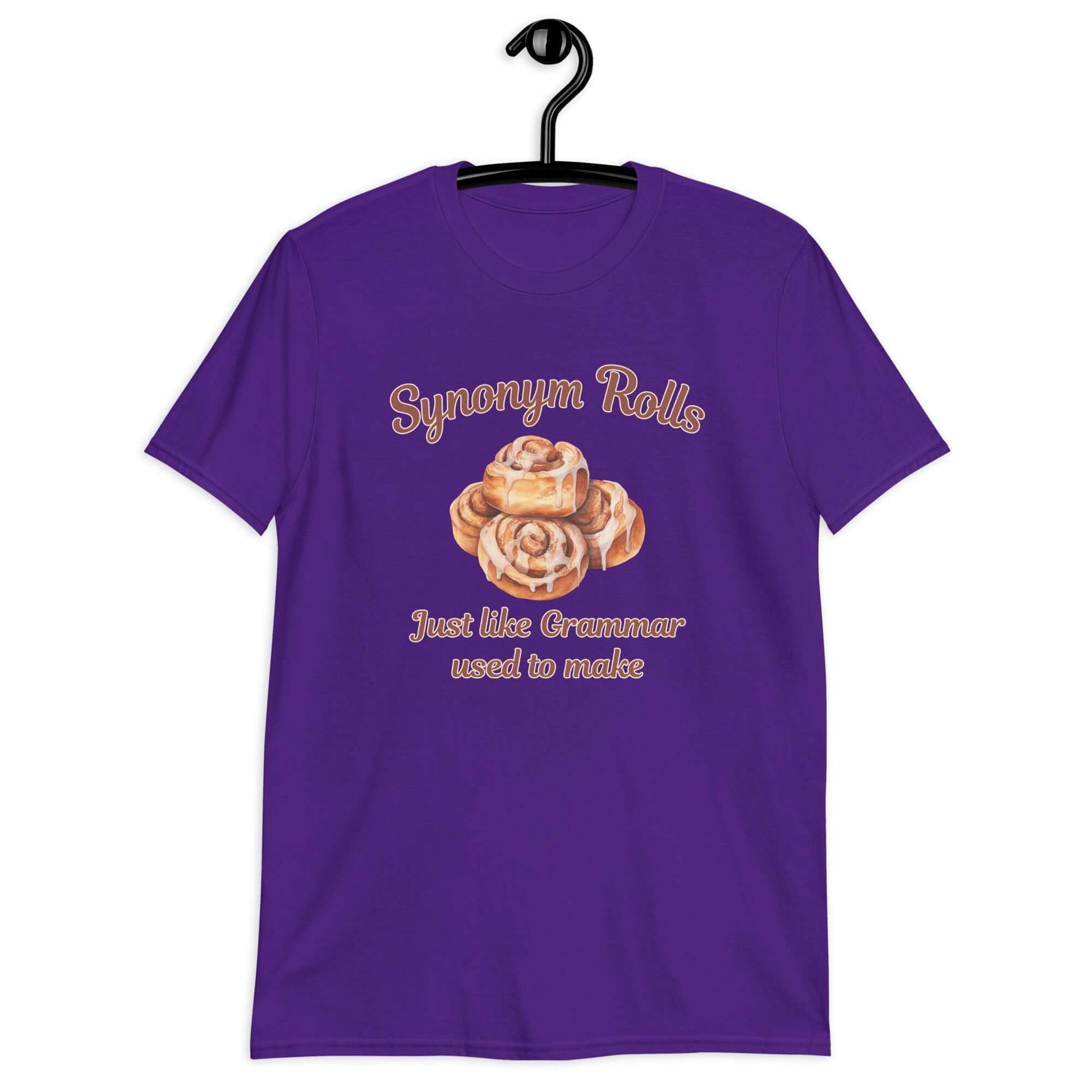 Purple t-shirt with an image of cinnamon rolls and the pun phrase Synonym rolls Just like Grammar used to make printed on the front.