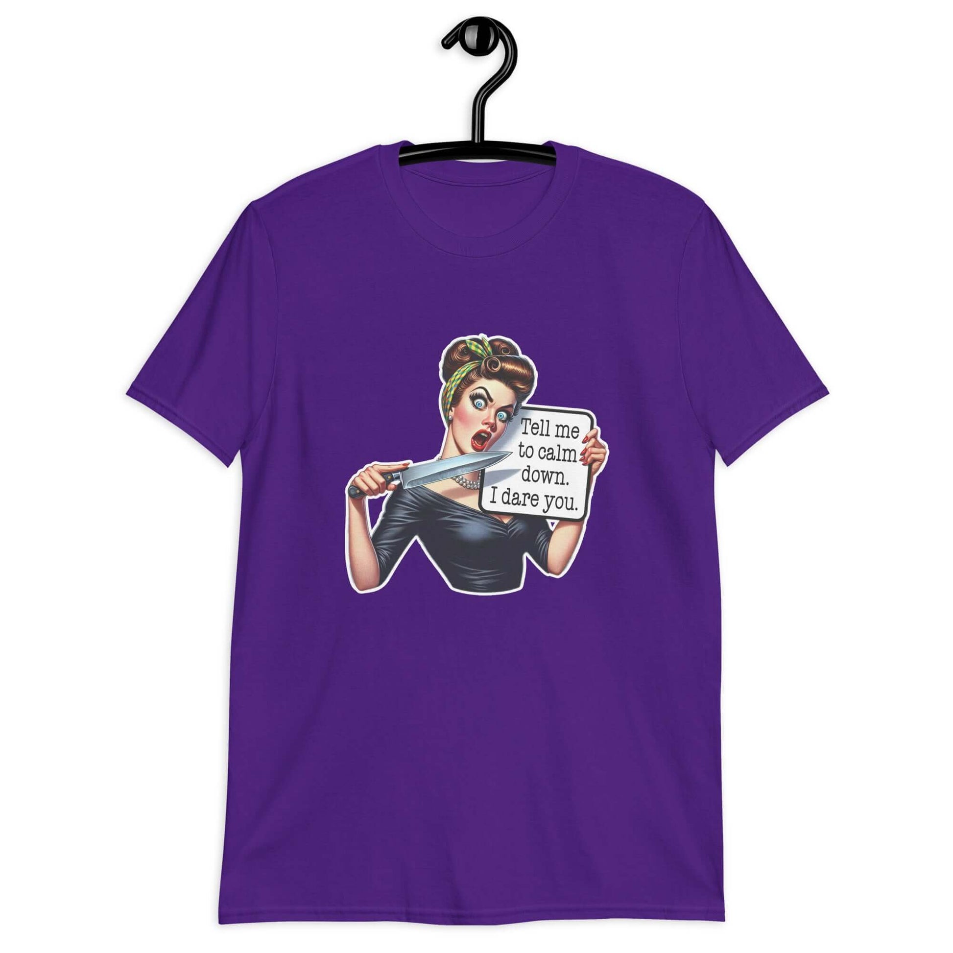 Purple t-shirt displayed on a hanger. The t-shirt has a graphic of an angry looking retro woman holding a knife and a sign. The sign says Tell me to calm down I dare you. The graphic is printed on the front of the shirt.