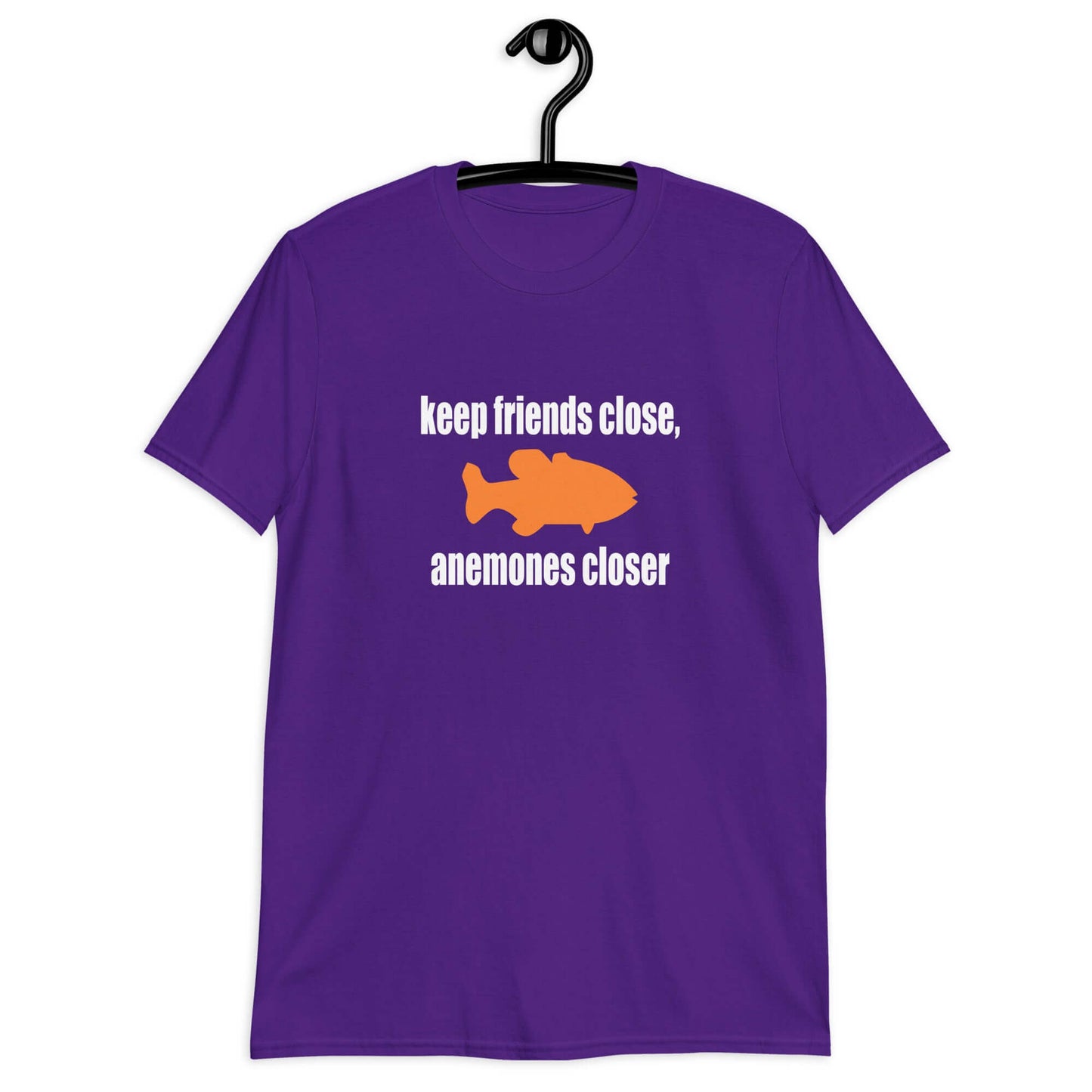 Purple t-shirt with the pun phrase Keep friends close, anemones closer with an image of an orange fish.