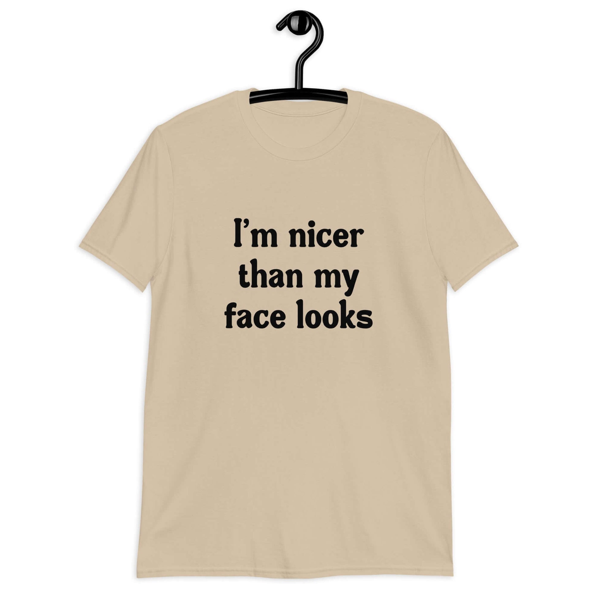 Sand t-shirt with the phrase I'm nicer than my face looks printed on the front.