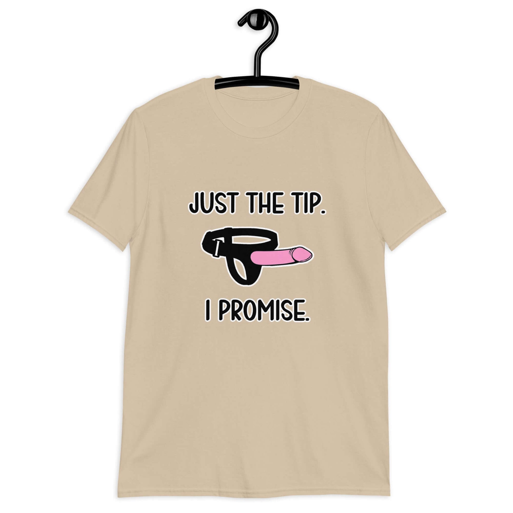 Sand color t-shirt that has an image of a strap-on dildo and the words Just the tip, I promise printed on the front. The graphics are pink, black and white.