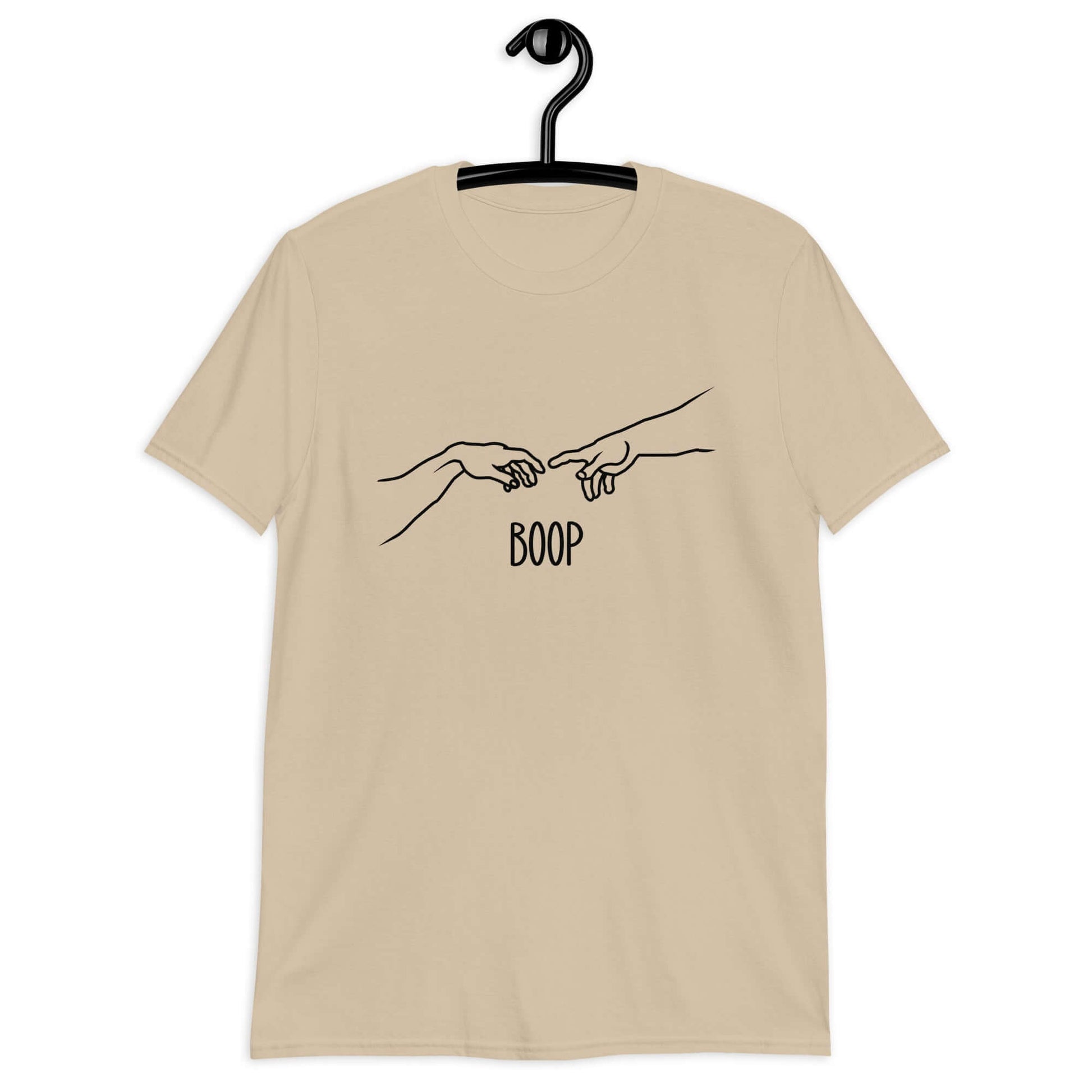 Sand color t-shirt with line drawing hands reaching out and touching in the center like they in the famous art creation of Adam. The word Boop is printed underneath.