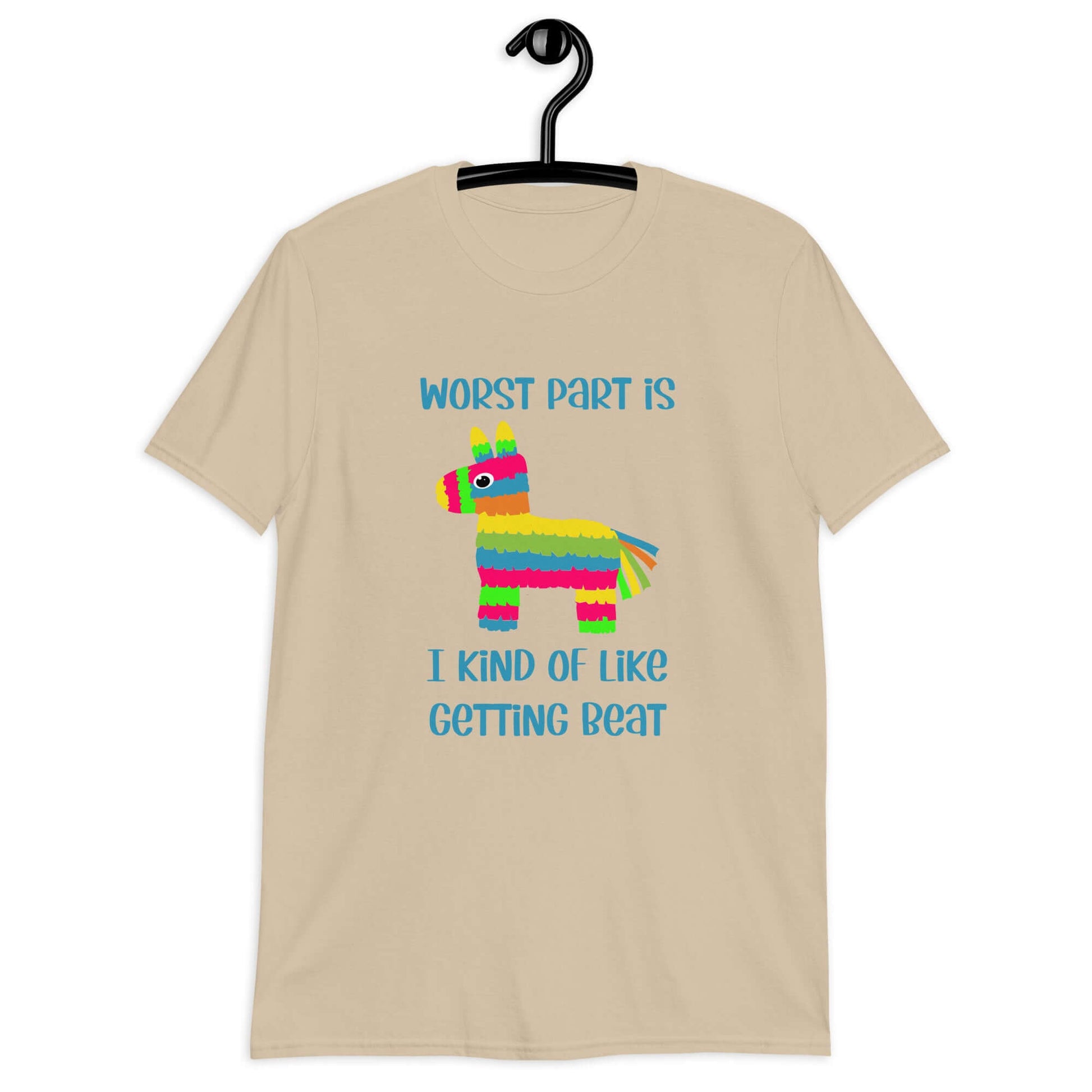 Sand color t-shirt with an image of a colorful donkey pinata with the phrase Worst part is I kind of like getting beat printed on the front.