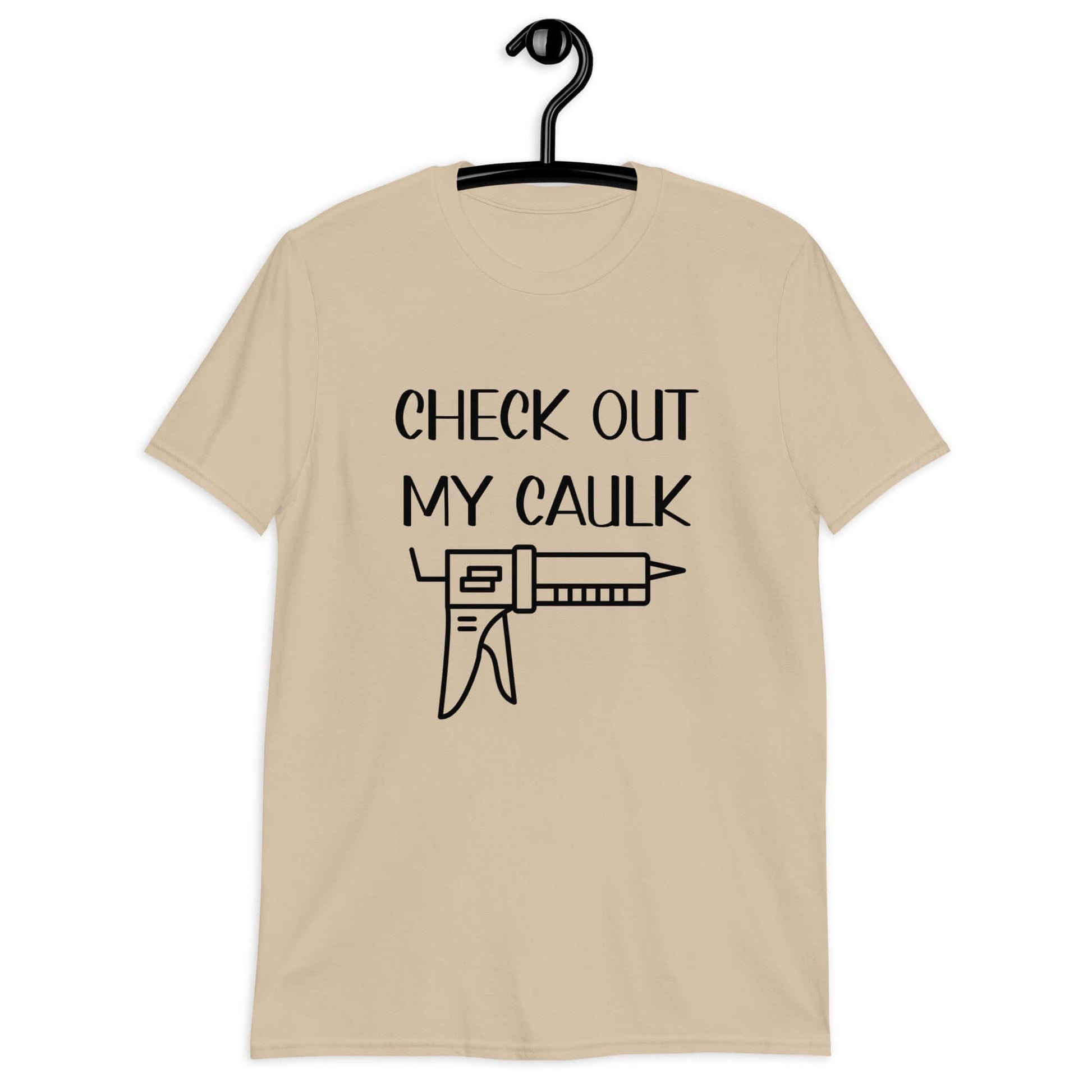 Sand t-shirt with the pun phrase Check out my caulk with a line drawing image of a caulking gun printed on the front.