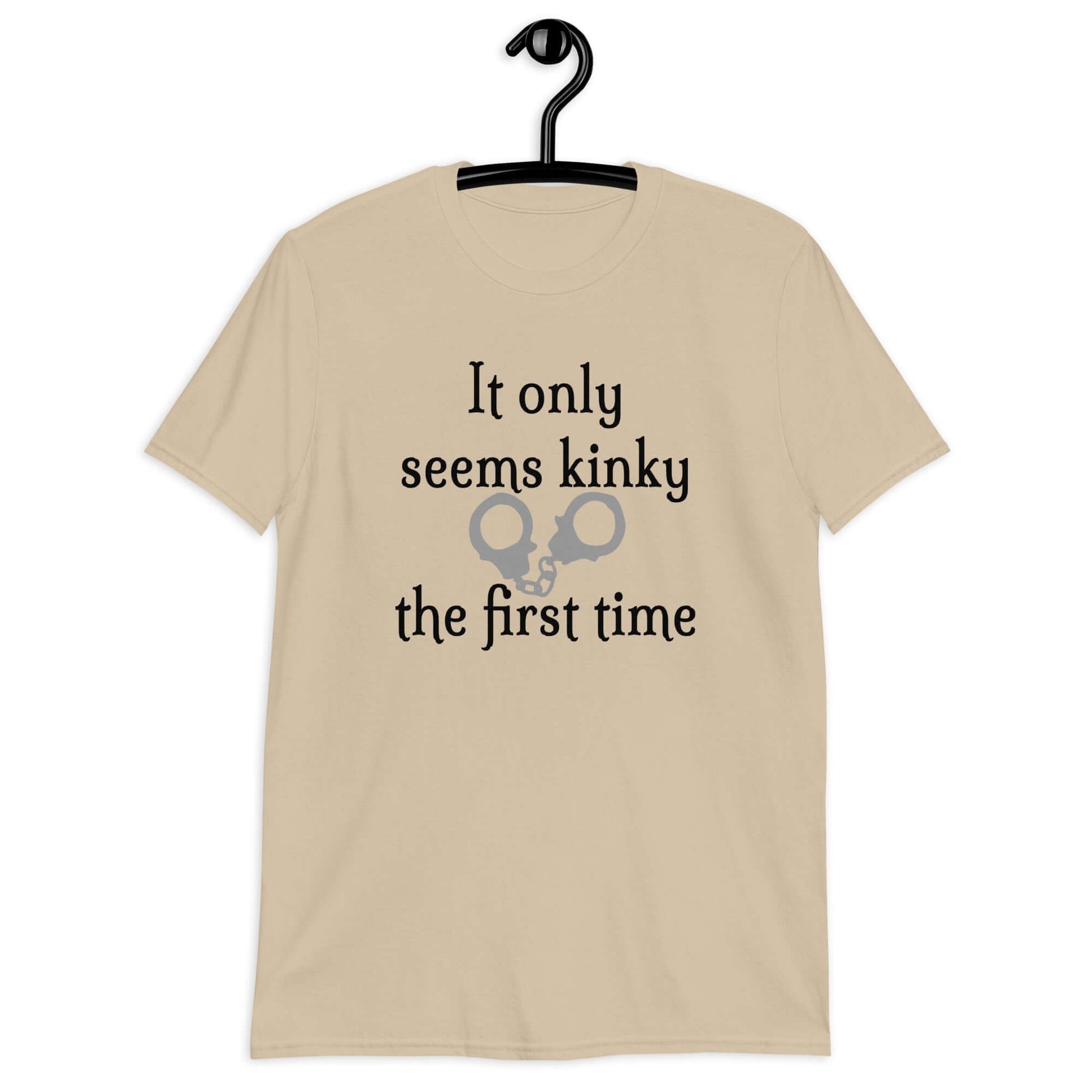 Sand t-shirt with the phrase It only seems kinky the first time printed on the front. There is an image of handcuffs with the text.