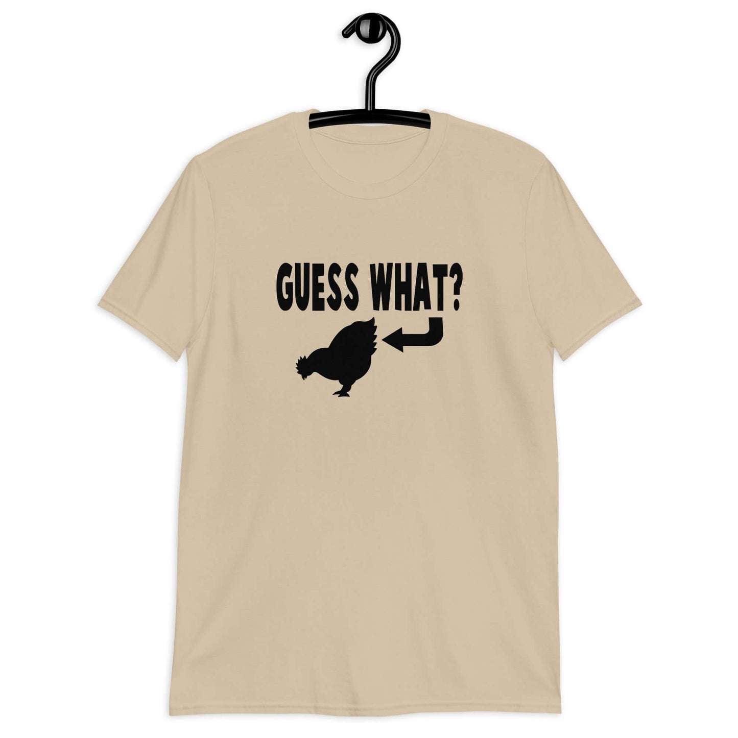 Sand t-shirt with an image of a chicken and the words Guess what question mark. There is an arrow pointing to the chickens butt. The graphics are printed on the front of the shirt.