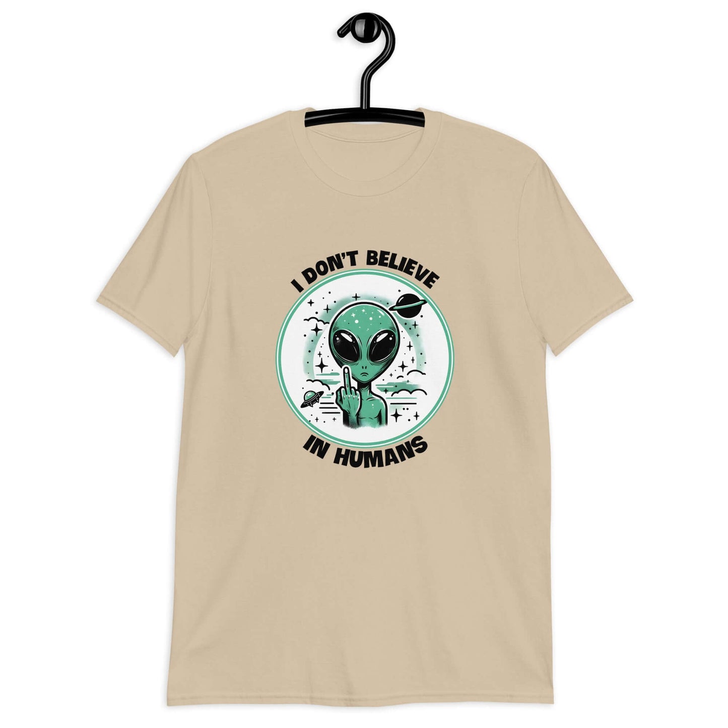 Sand color t-shirt with an image of an alien flipping the middle finger. The words I don't believe in humans are printed around the image. The graphics are printed on the front of the shirt.